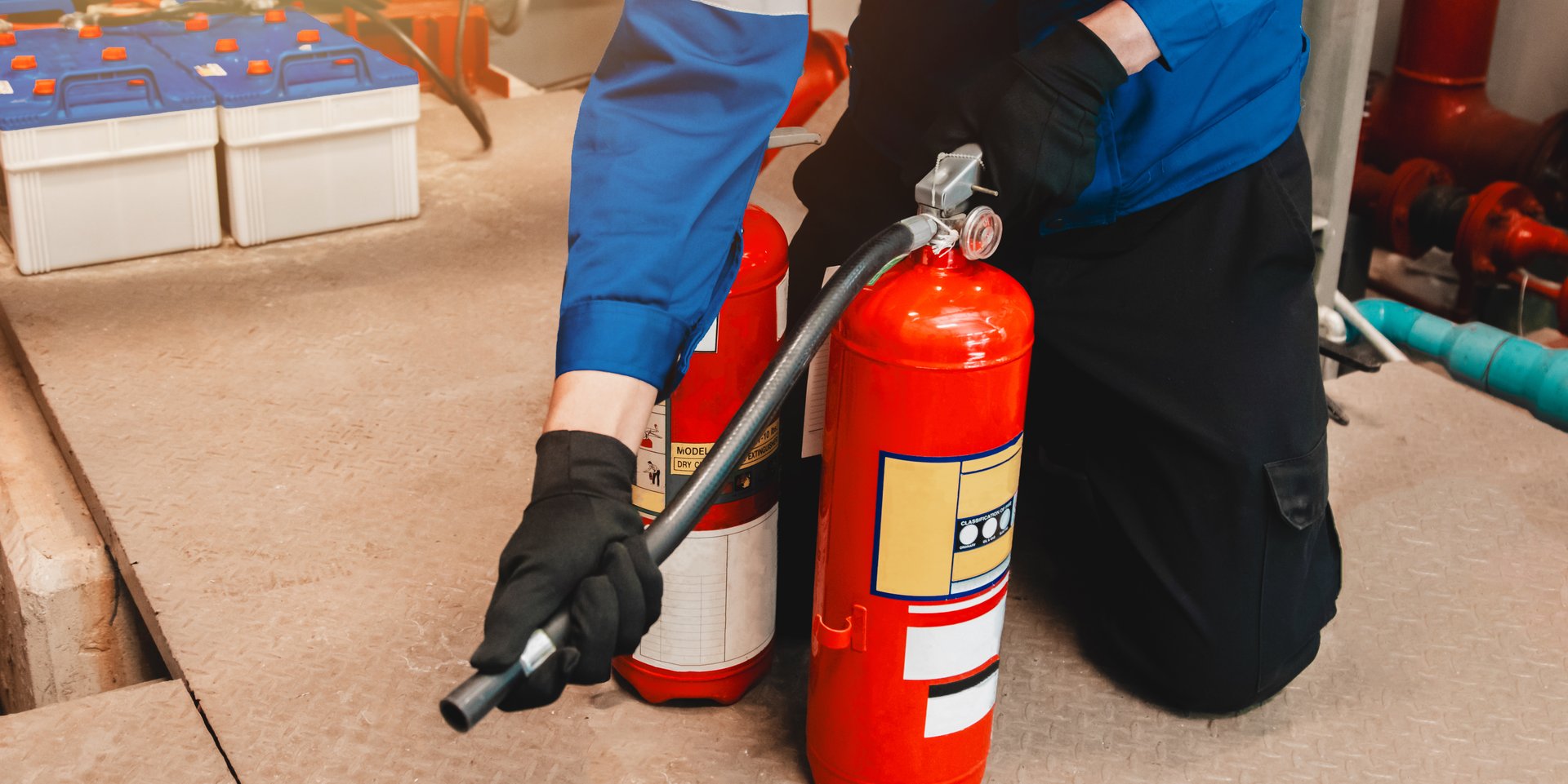 Engineer checks fire extinguisher in fire control room to ensure safety. When an emergency occurs