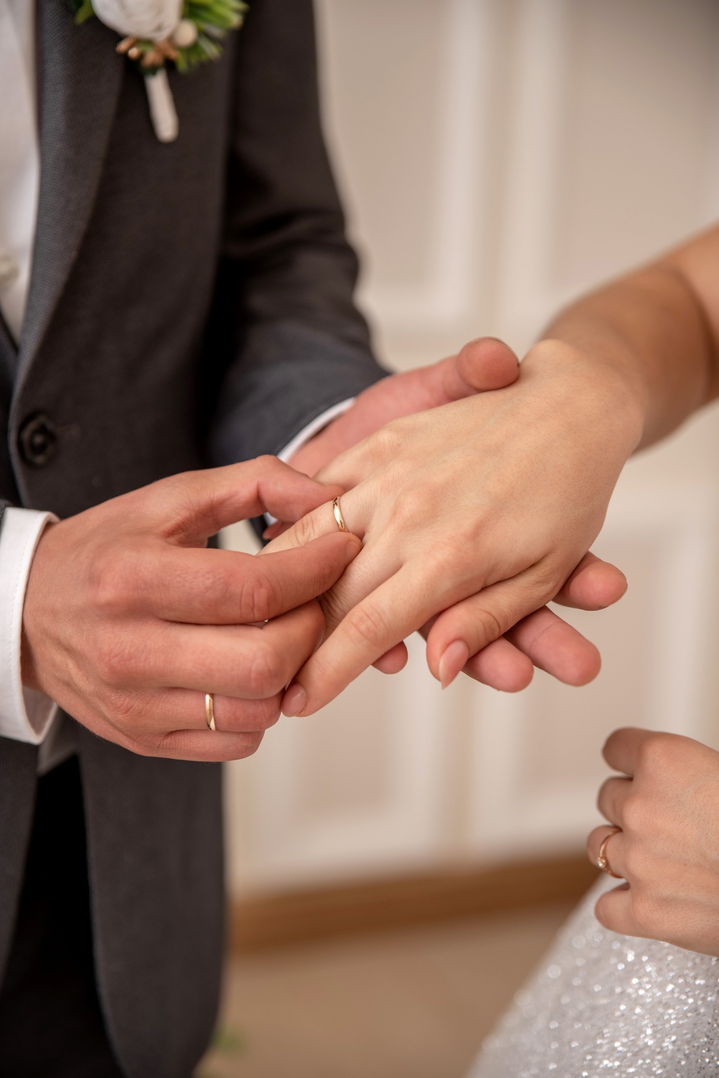 Groom puts a wedding ring on the bride's hand