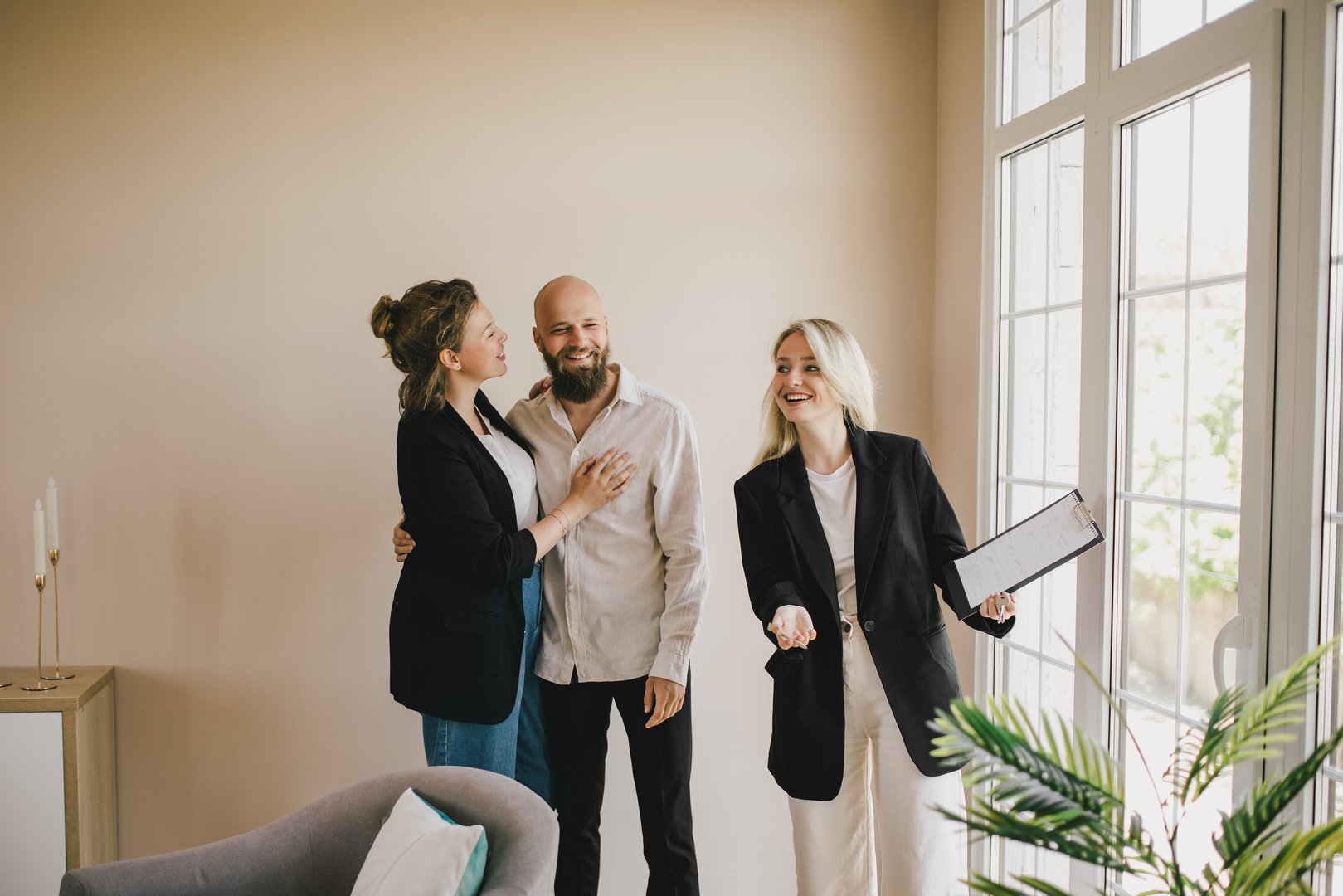 Real estate agent demonstrating a new apartment to a happy couple. Buying a property.
