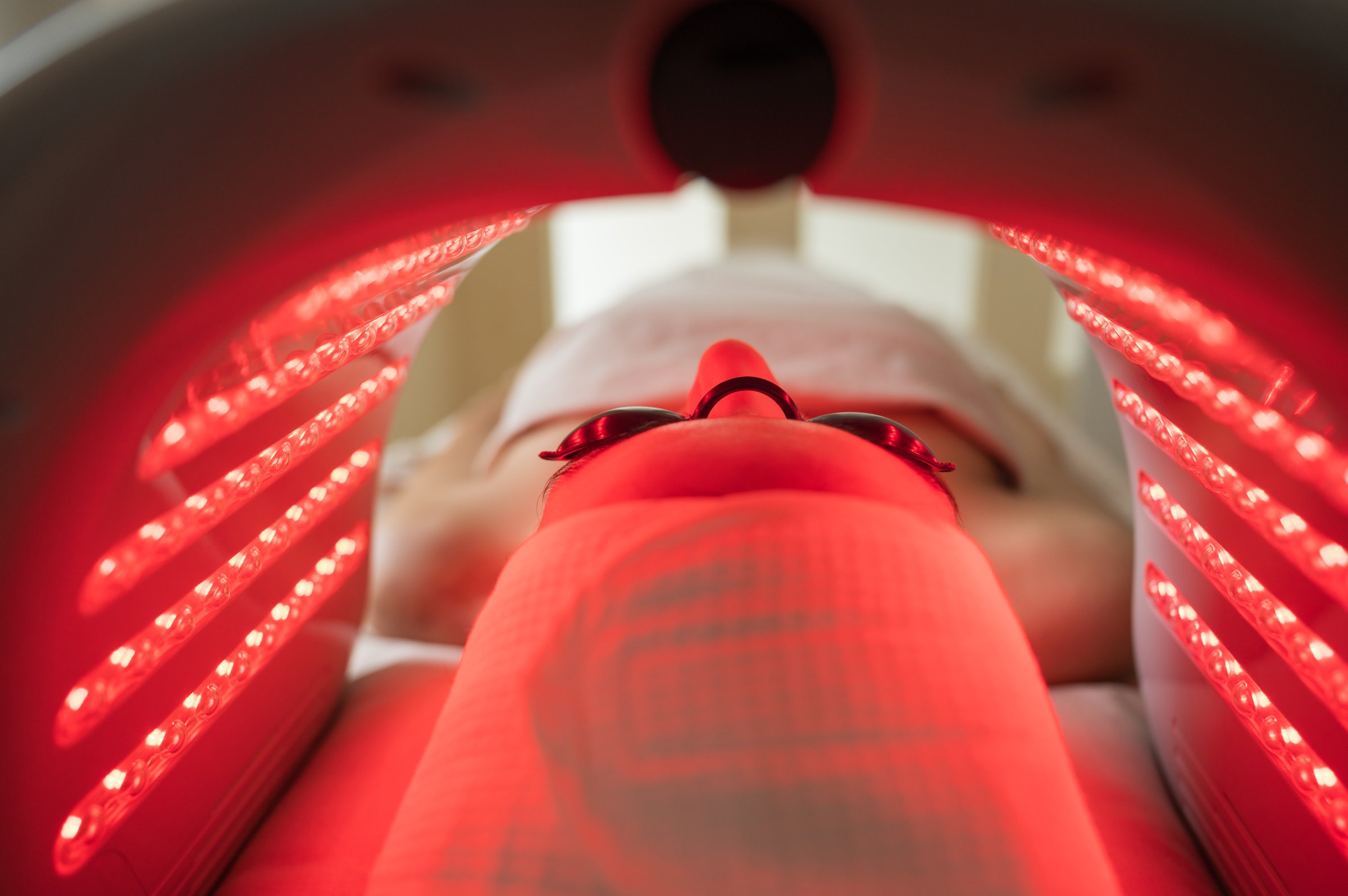 Client enjoying Hydradermabrasian LED light therapy administered by a skilled esthetician in a modern beauty clinic, enhancing skin health and rejuvenation