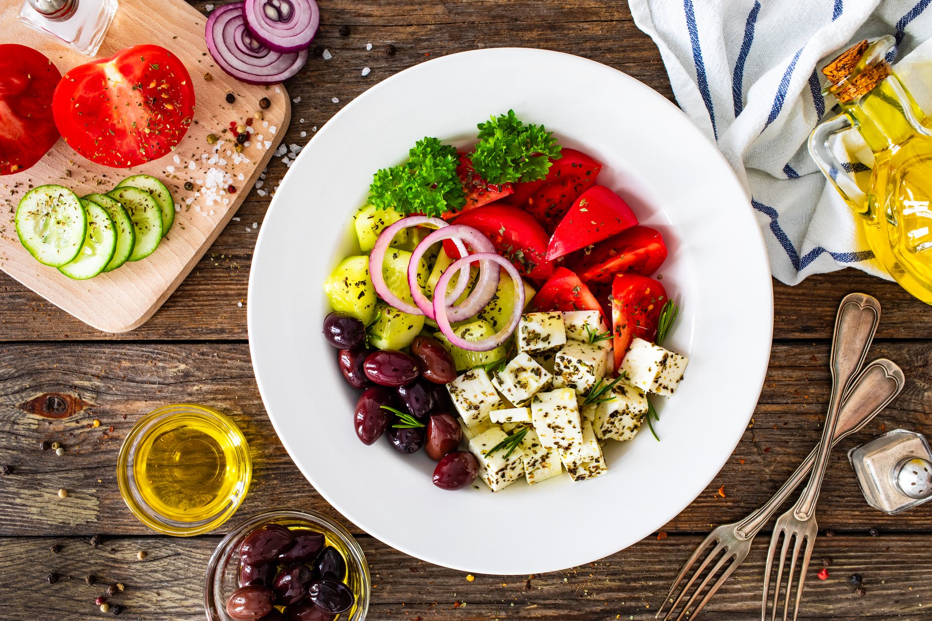 Greek style salad - fresh vegetables with feta cheese and pita bread on wooden table