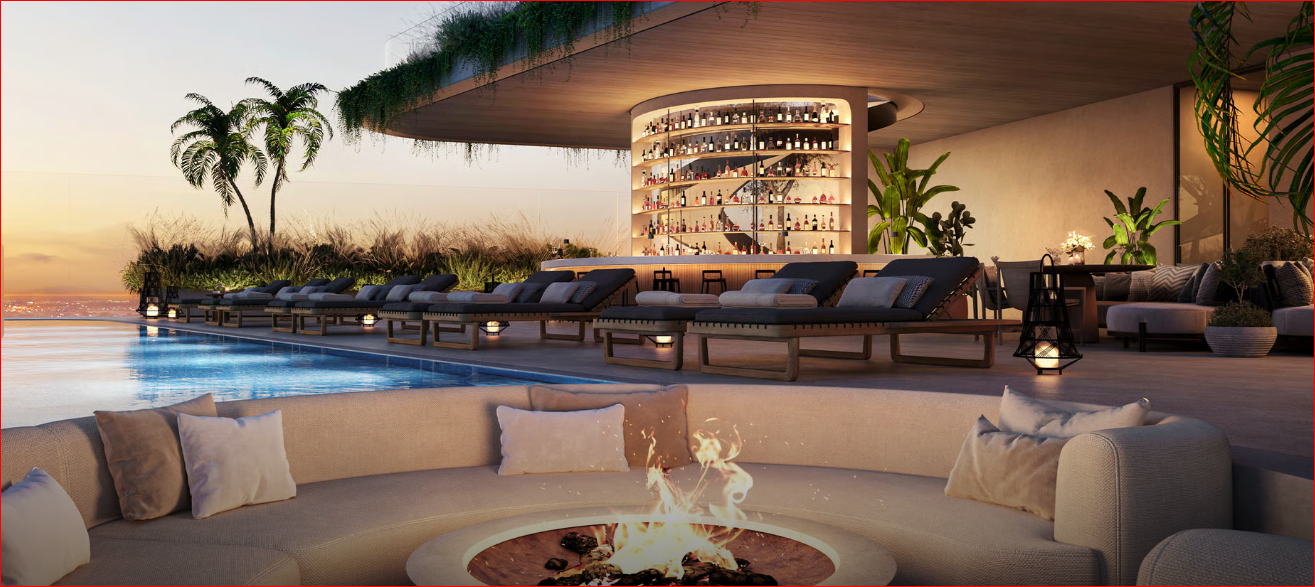 A rooftop lounge with pool, fire pit, bar area, and city view at sunset, featuring comfortable seating and palm trees.