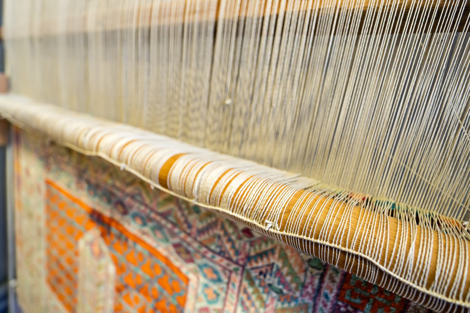 Traditional handwoven silk rug on loom showing delicate fibers requiring professional cleaning care