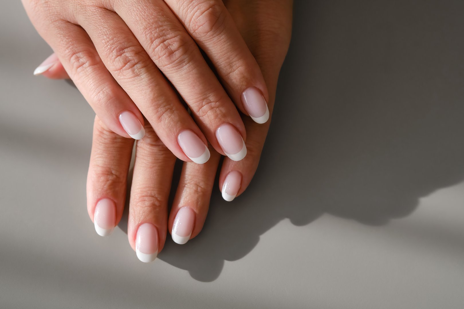 Hands with French manicure. New Perfect fingernails of woman.   Care for sensuality female hands. Shallow depth of field