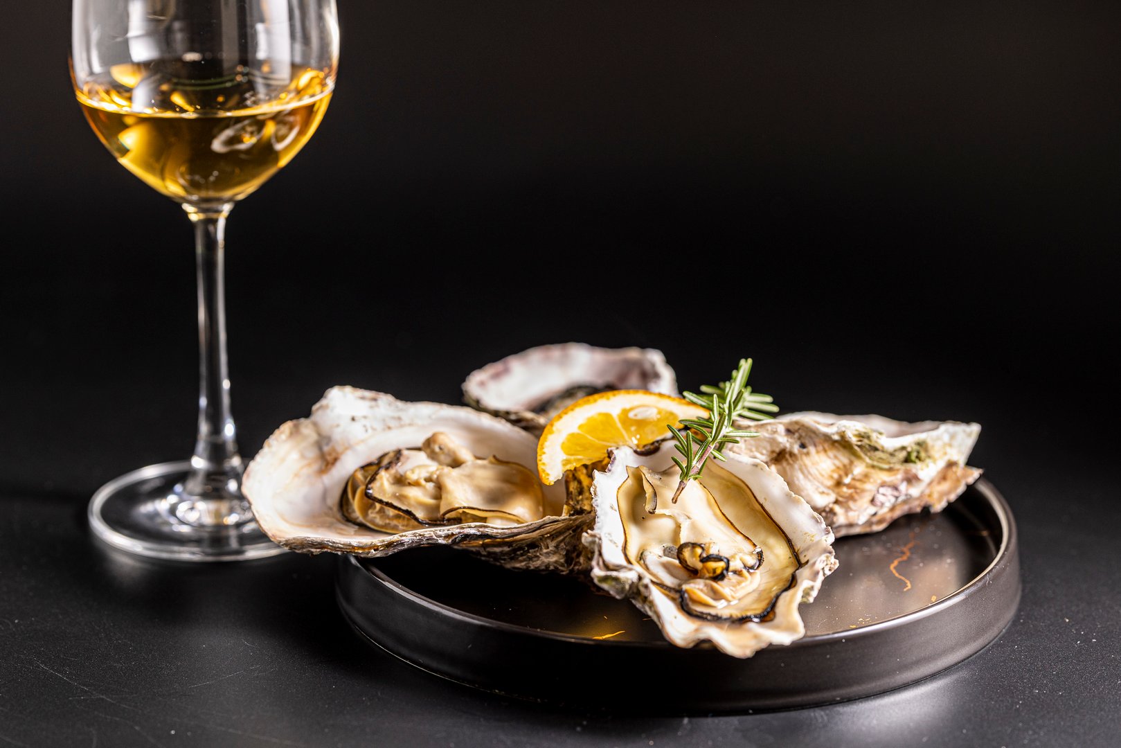 I photographed very fresh raw oysters and white wine against a black background.