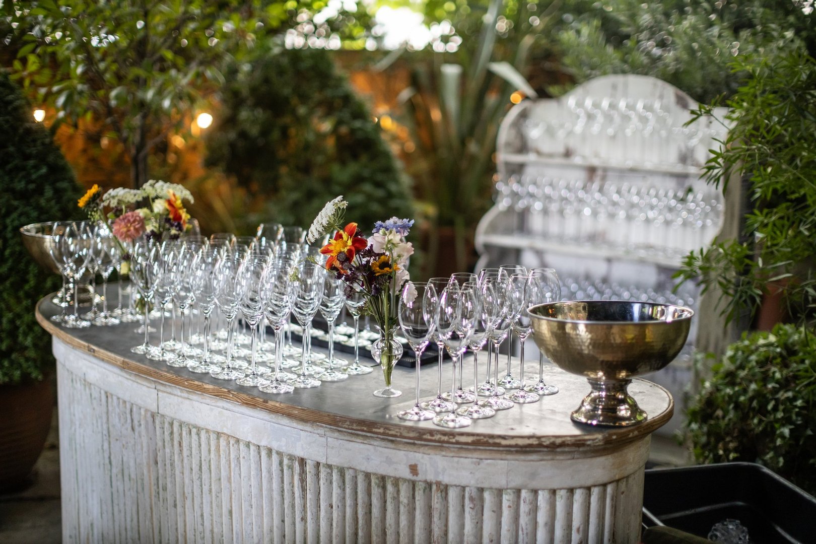 Elegant Outdoor Bar Setup with Wine Glasses and Flowers