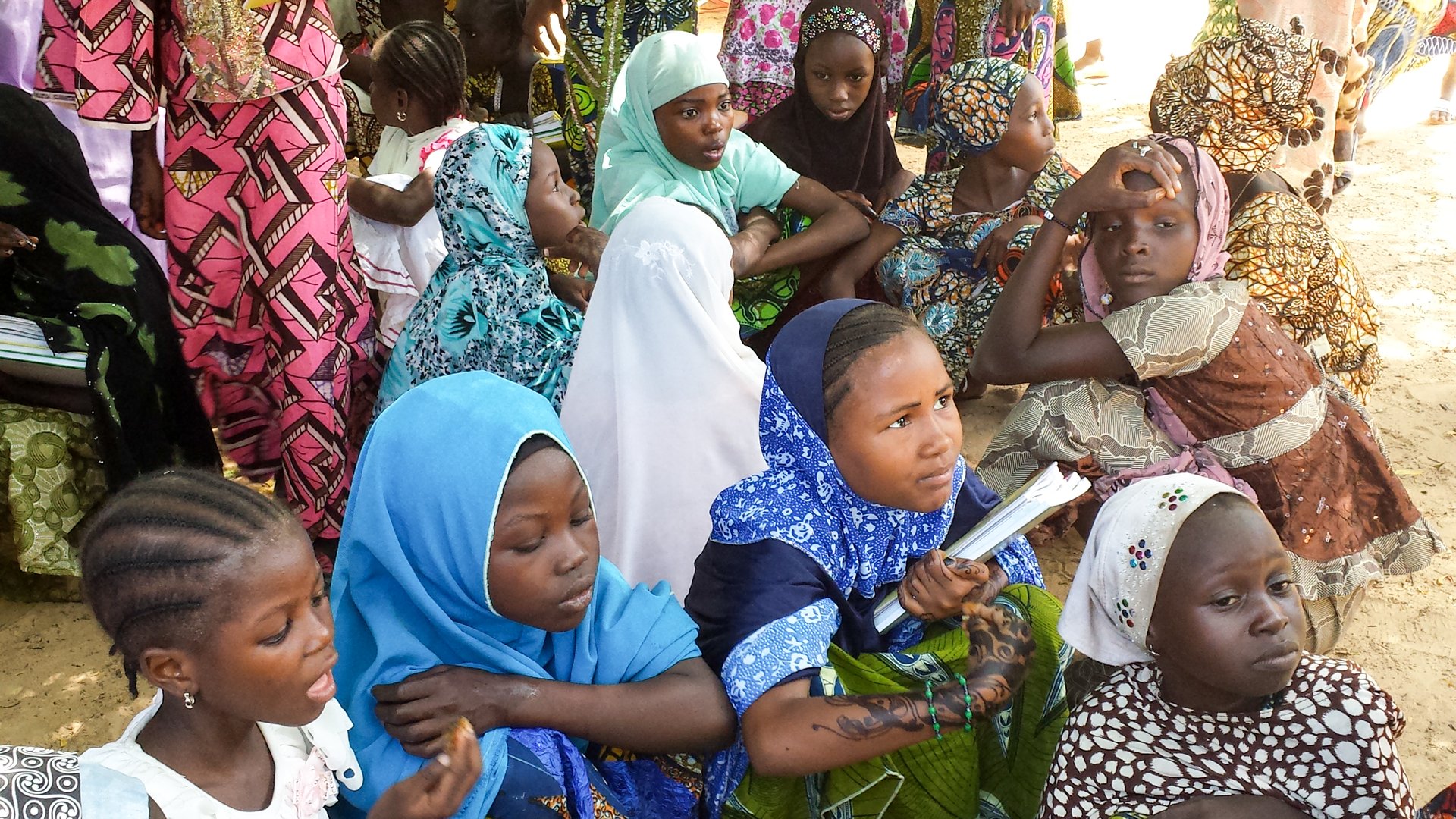 October 2013 – Maradi, Niger: Muslim school girls getting protection from the extreme heat in Niger under a shadow of a tree, outside of their school. They are waiting for their lunch in the country-side of Niger, in Africa. Picture taken as part of a school feeding monitoring programme.