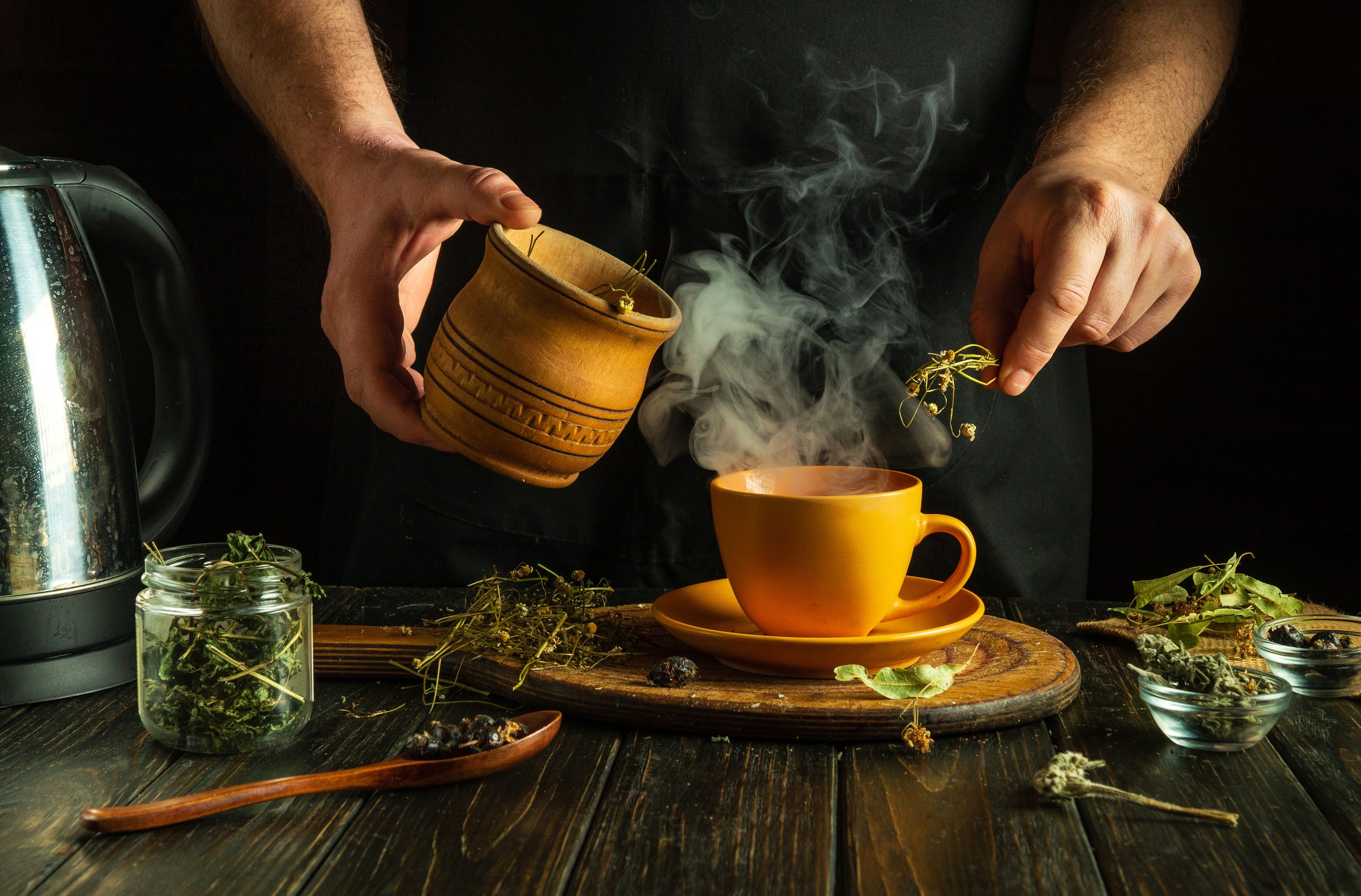 The cook prepares medicinal herbal tea on the kitchen table. Prevention of viral diseases using traditional medicine.