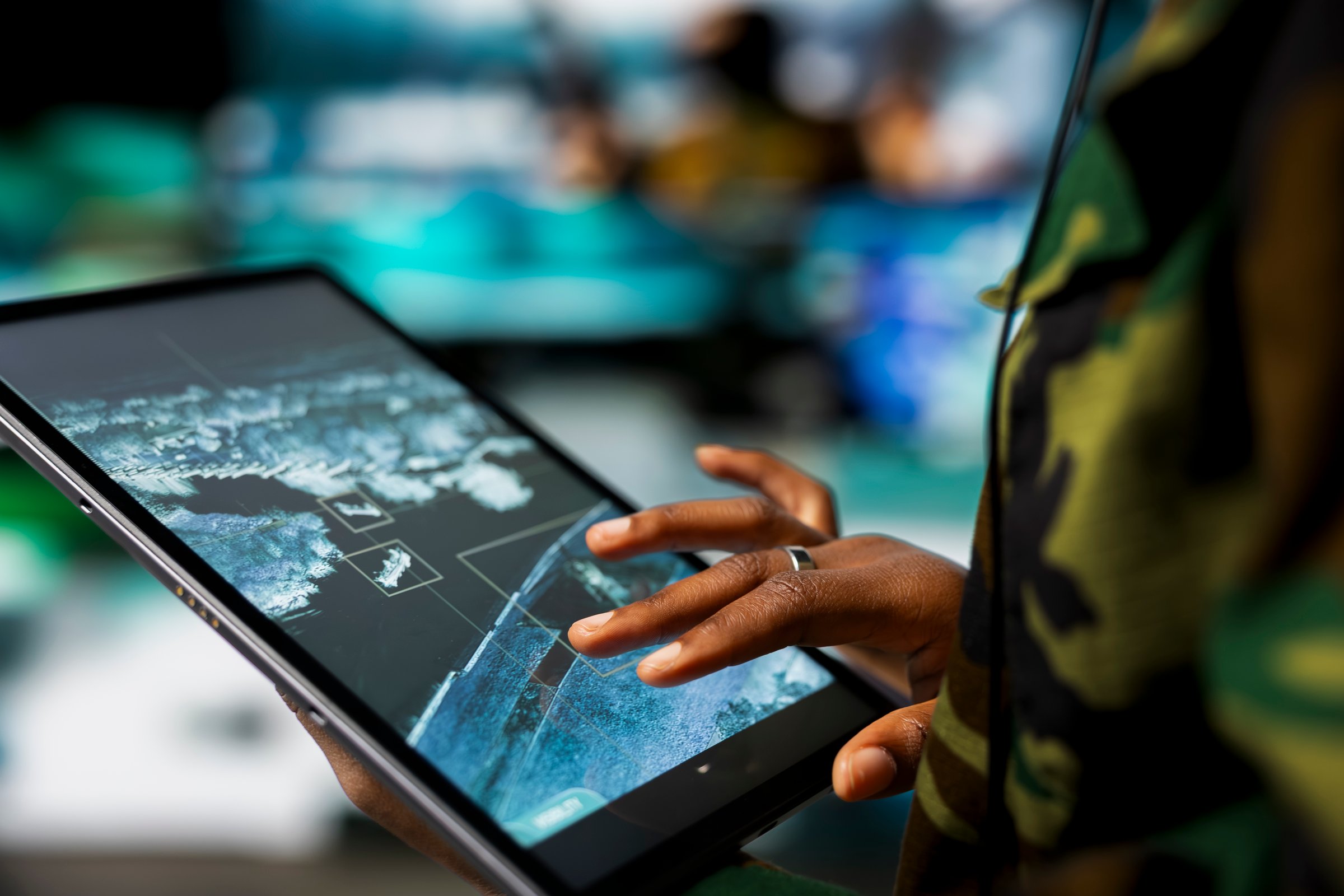 Close up of military defense security agent using device to track threats. Counterterrorism division officer in command post using target acquisition tech on tablet to detect enemy location