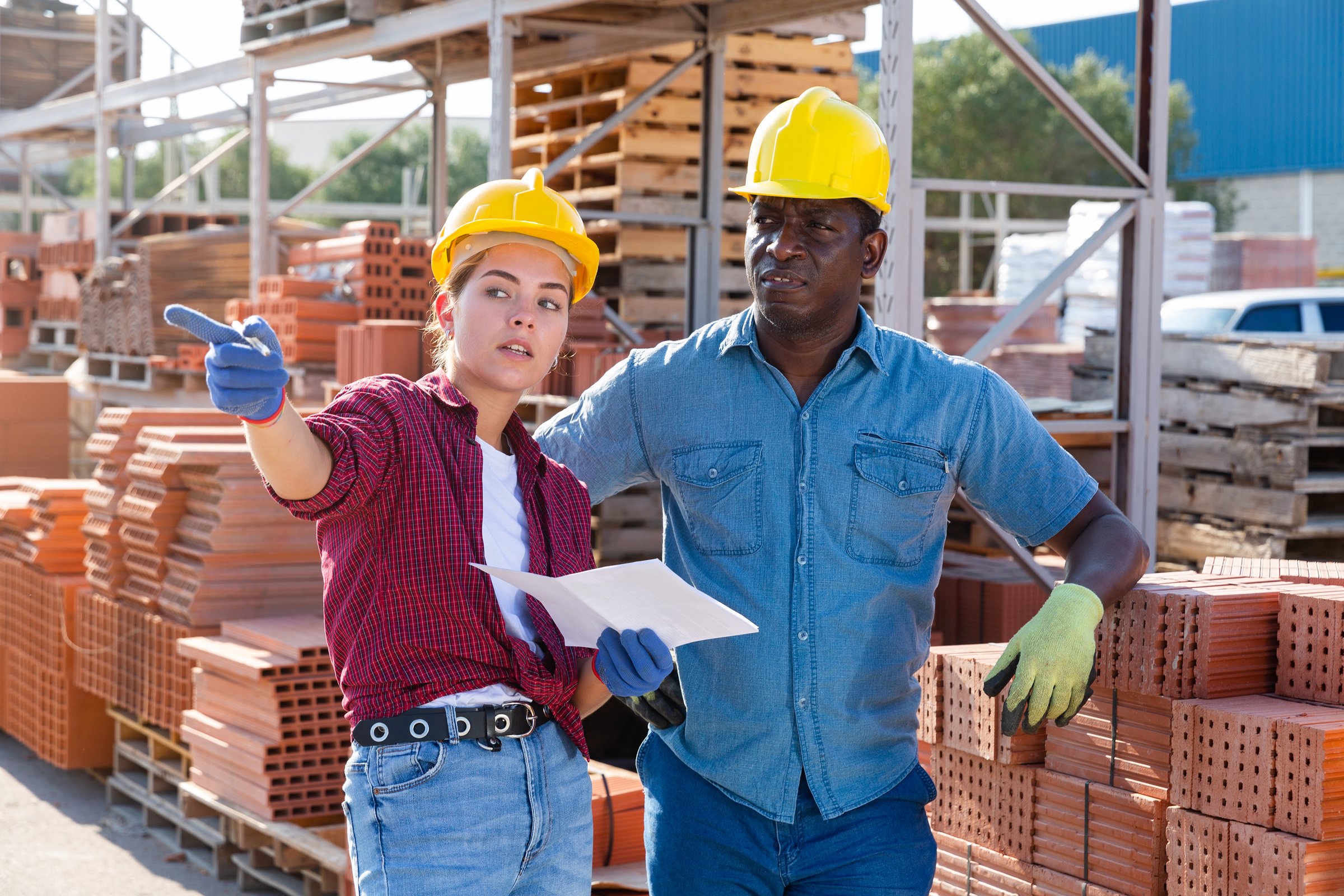 African male worker with young woman keep track of the number of bricks at the site of hardware store