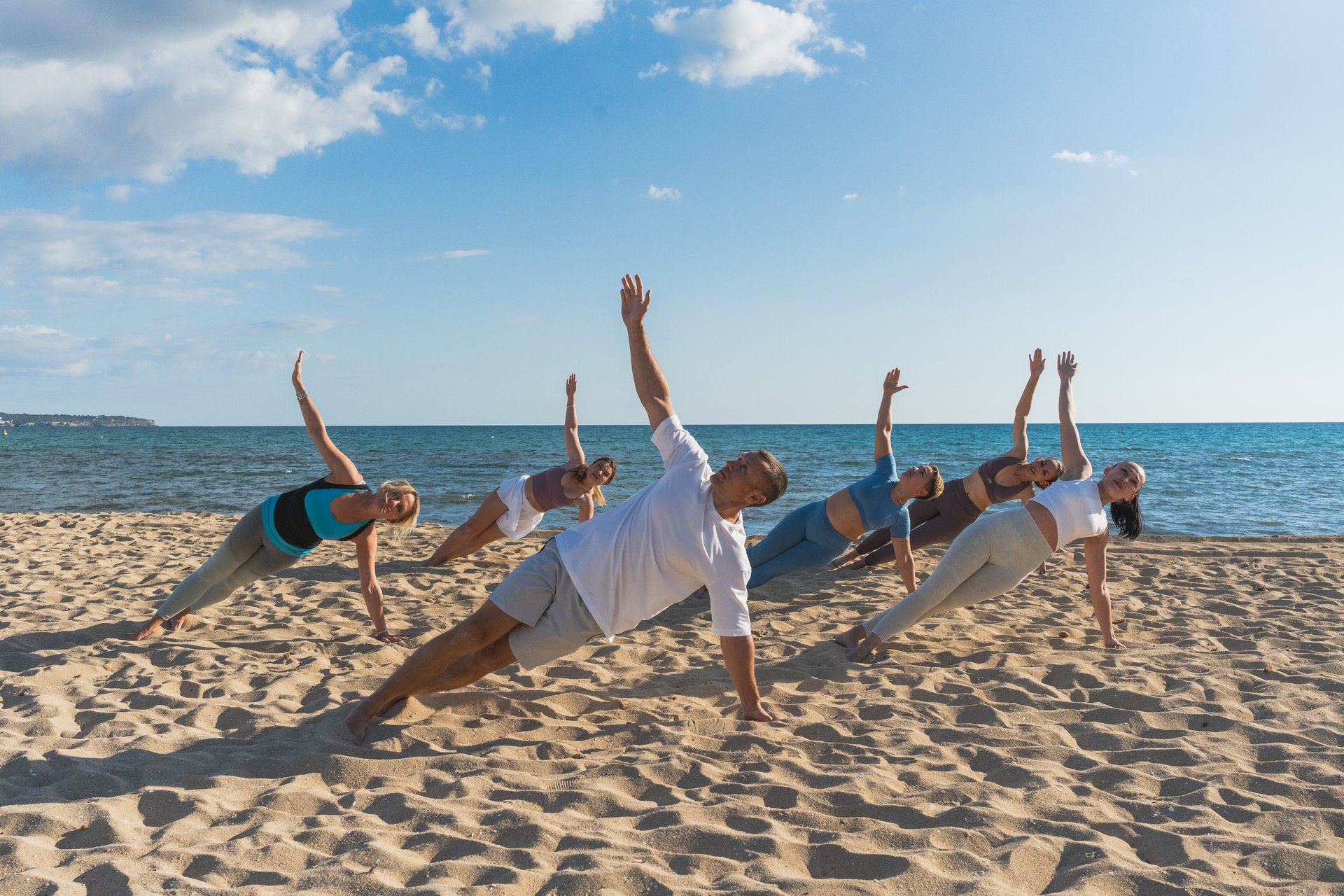 People practicing yoga side planks by the ocean. Concept of yoga, strength, balance.