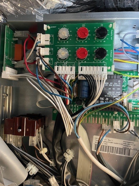 Close-up of an electronic circuit board with wires, connectors, and components inside a device.