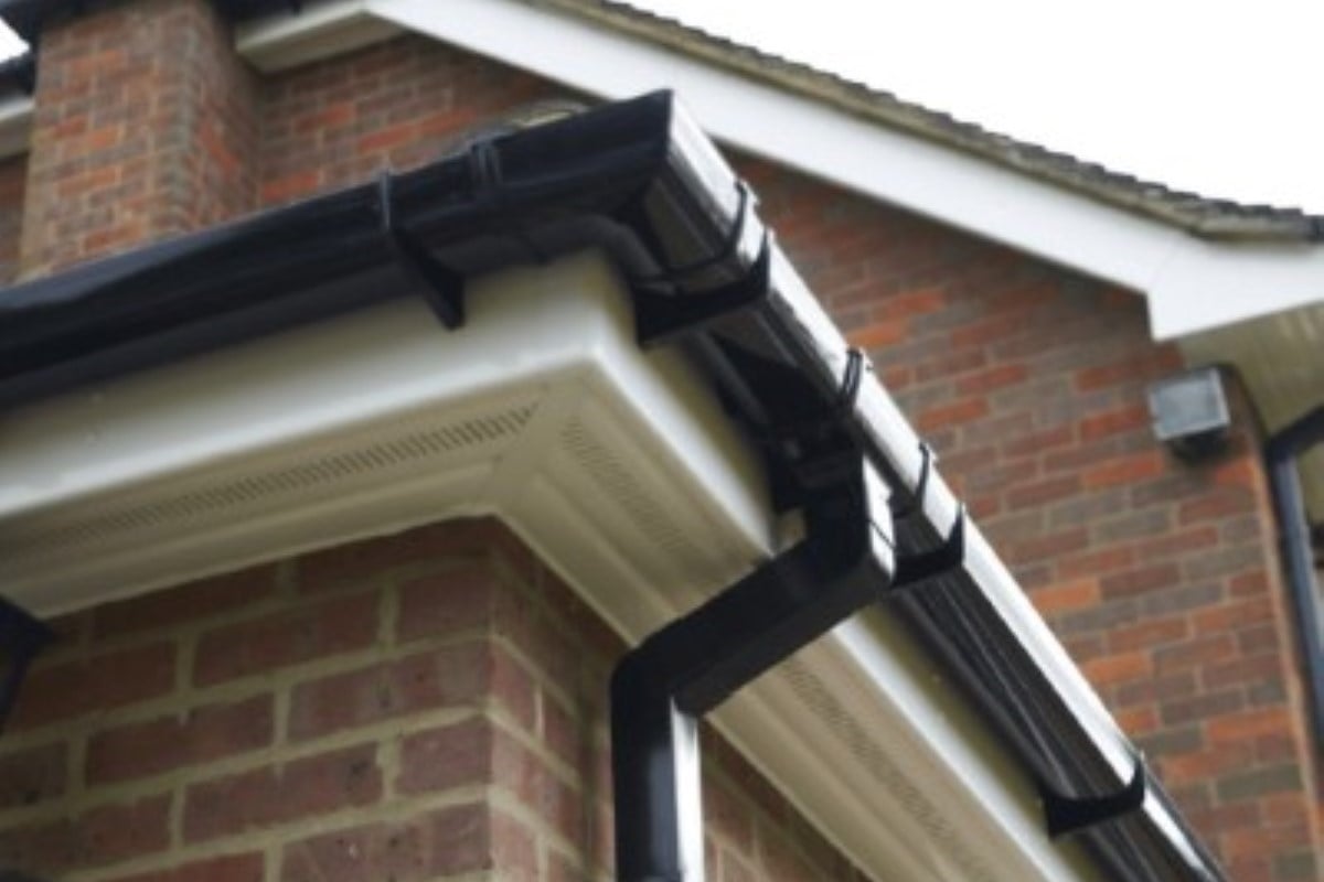Professional installation of white PVC guttering system on residential property