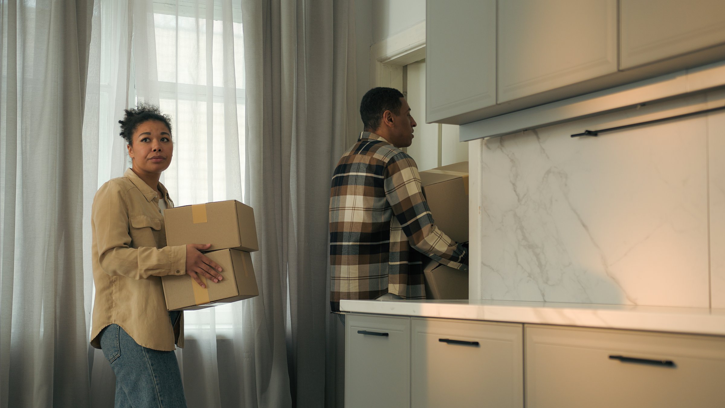 Frustrated sad couple ethnic woman man African American family upset worried home owners tenants moving out house with cardboard boxes bankruptcy leave apartment eviction divorce debt credit mortgage. High quality 4k footage