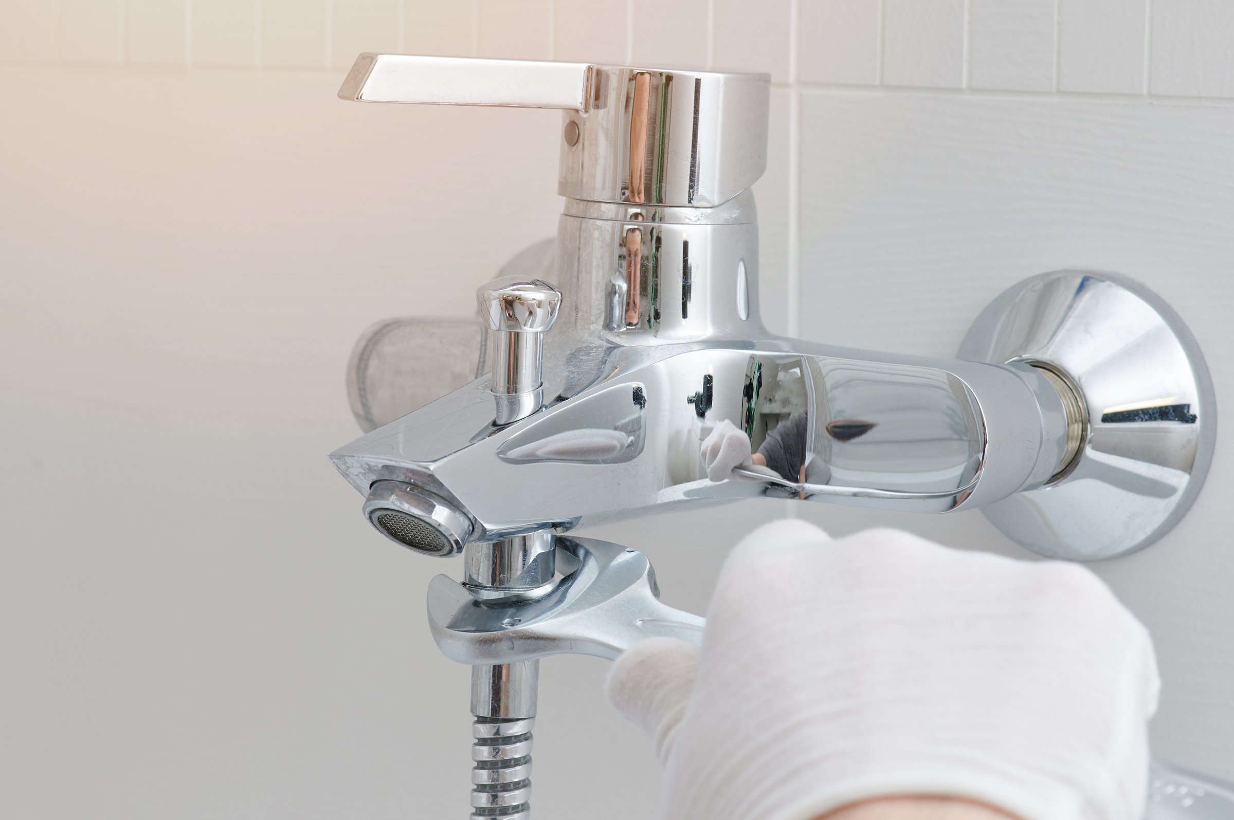 Fixing faucet in bathroom. Hand with wrench installing tap