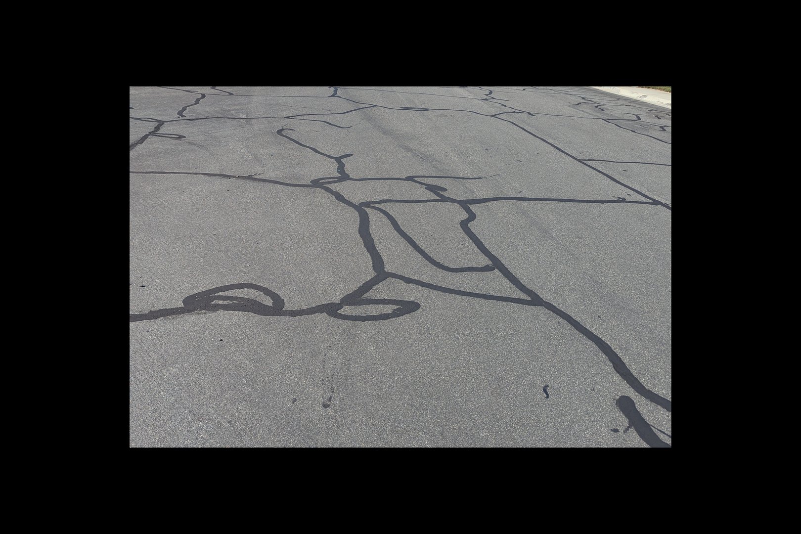 Repairs to cracks in an asphalt road.