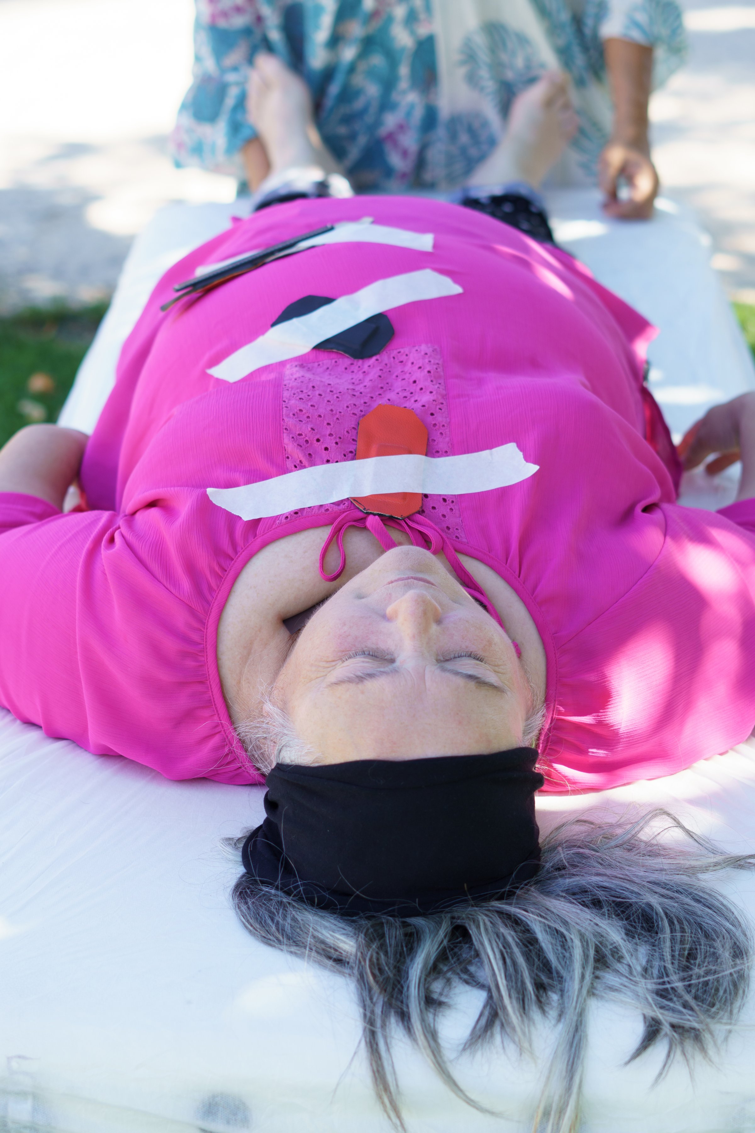 a female therapist giving a biomagnetism treatment to a patient lying on a stretcher