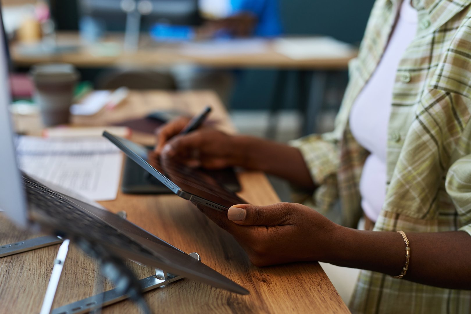African woman using digital tablet with stylus at desk