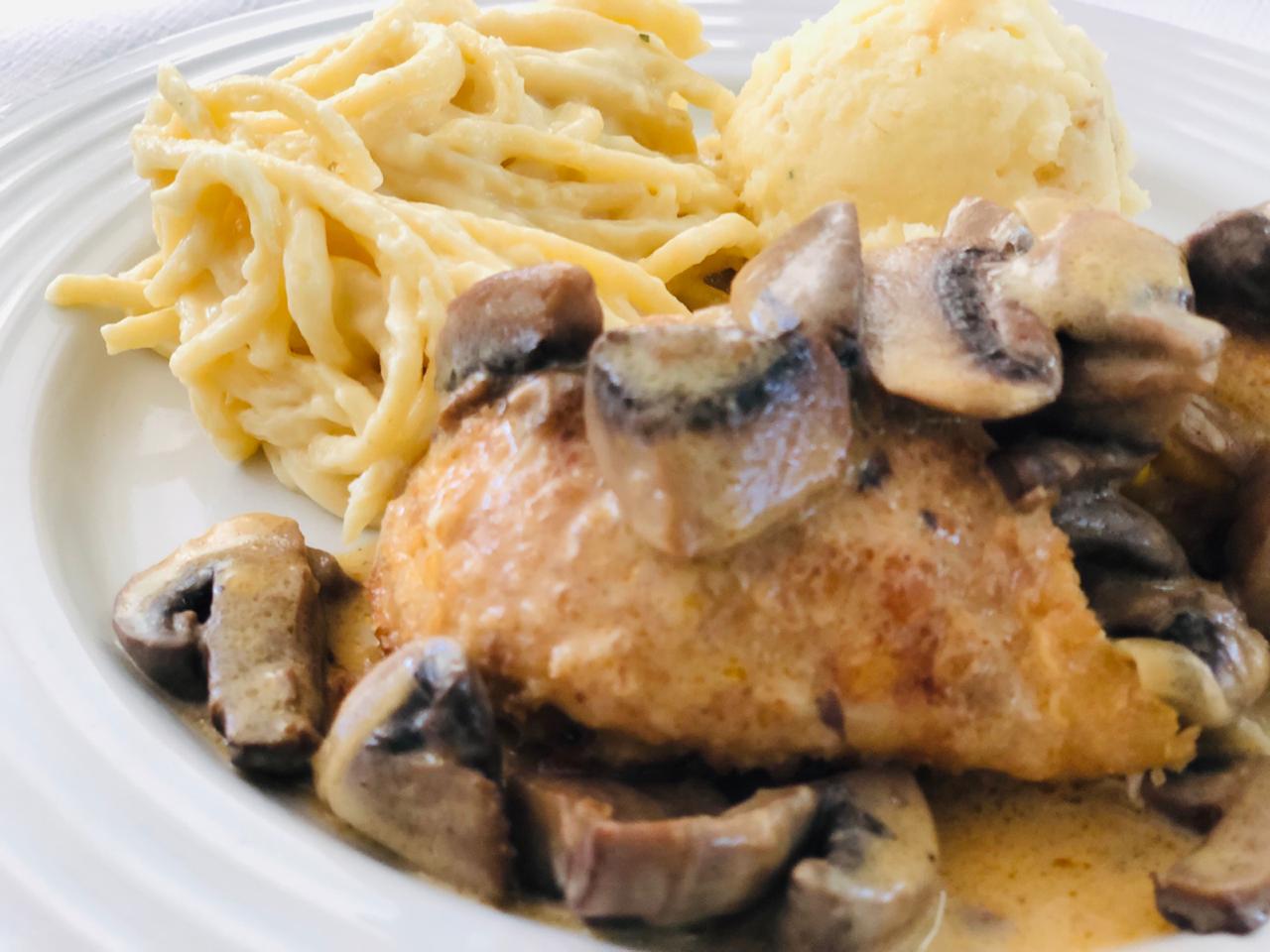 Chicken with mushroom sauce, pasta, and mashed potatoes on a white plate.