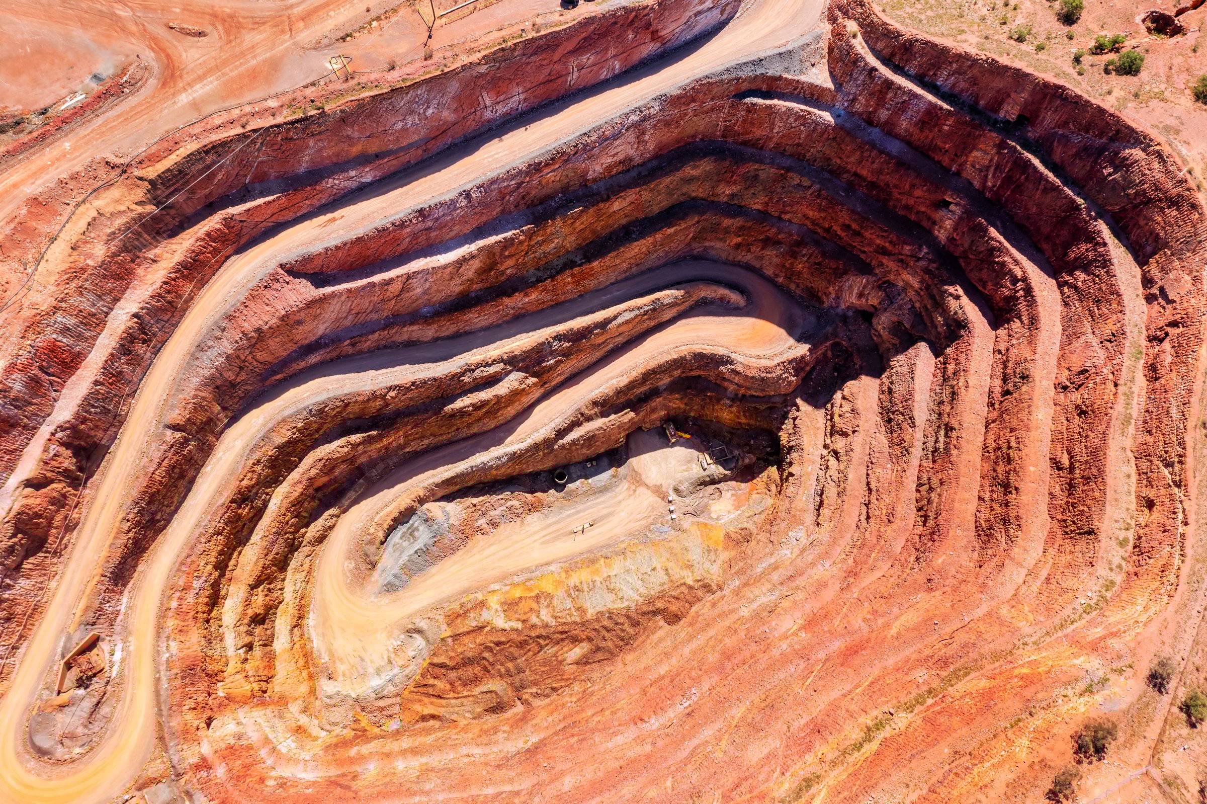 Layers of deep open pit copper mine in Cobar town of outback Australia - aerial top down view.