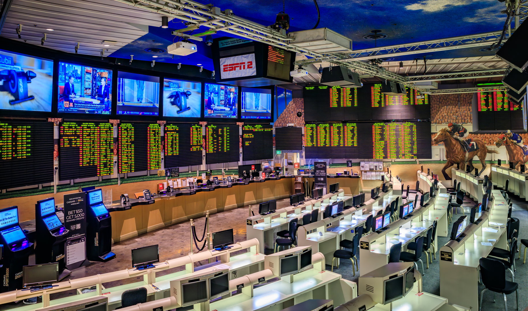 Las Vegas, Nevada, USA - October 25, 2021: An empty sportsbook with numerous screens displaying odds and live sports, and rows of betting stations