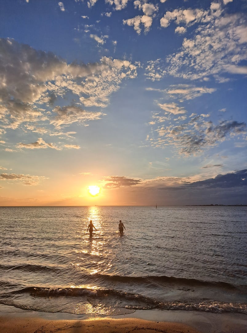 Two people going for a swim at sunset time