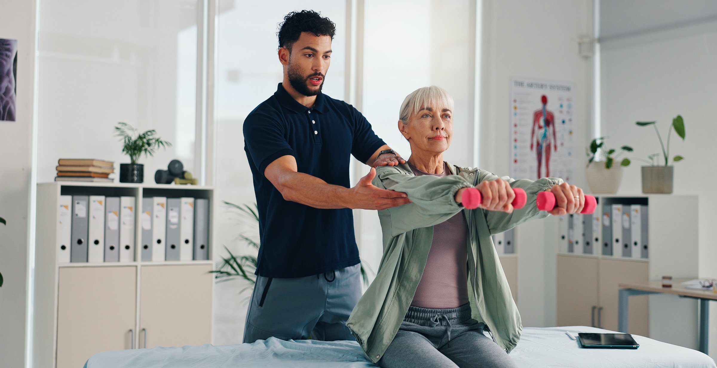 Physiotherapist, help or senior woman with dumbbells for rehabilitation, muscle exercise or body health. Shoulder mobility, weights or physiotherapy client with physical recovery, support or balance