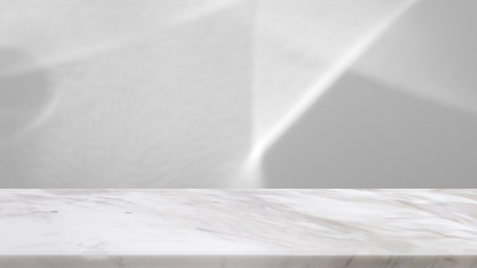 Marble table top with abstract shadow drop on white wall background for mockup product display