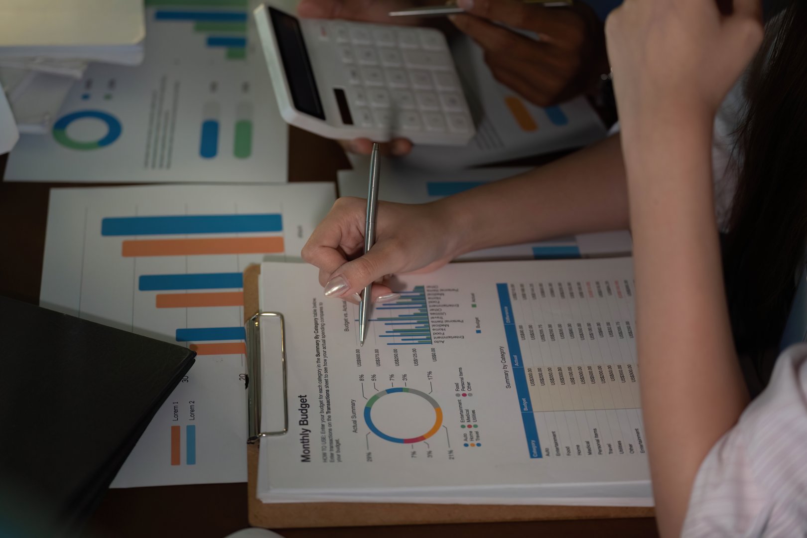 Team members collaborating on budget planning, analyzing financial data with charts and reports. Focus on teamwork and financial responsibility.