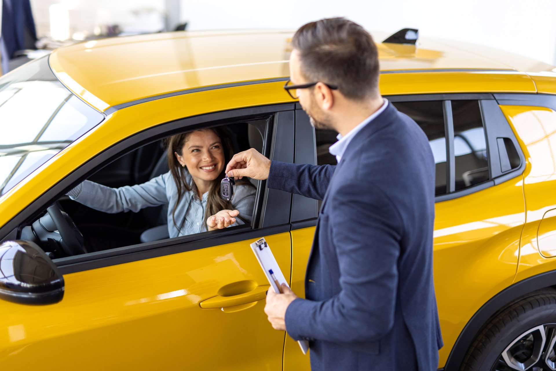 Car Renting Service. Young Woman Driver Taking Keys From Manager While Sitting In Rental Auto, Smiling woman Enjoying Vehicle Leasing, Cropped Image, Closeup