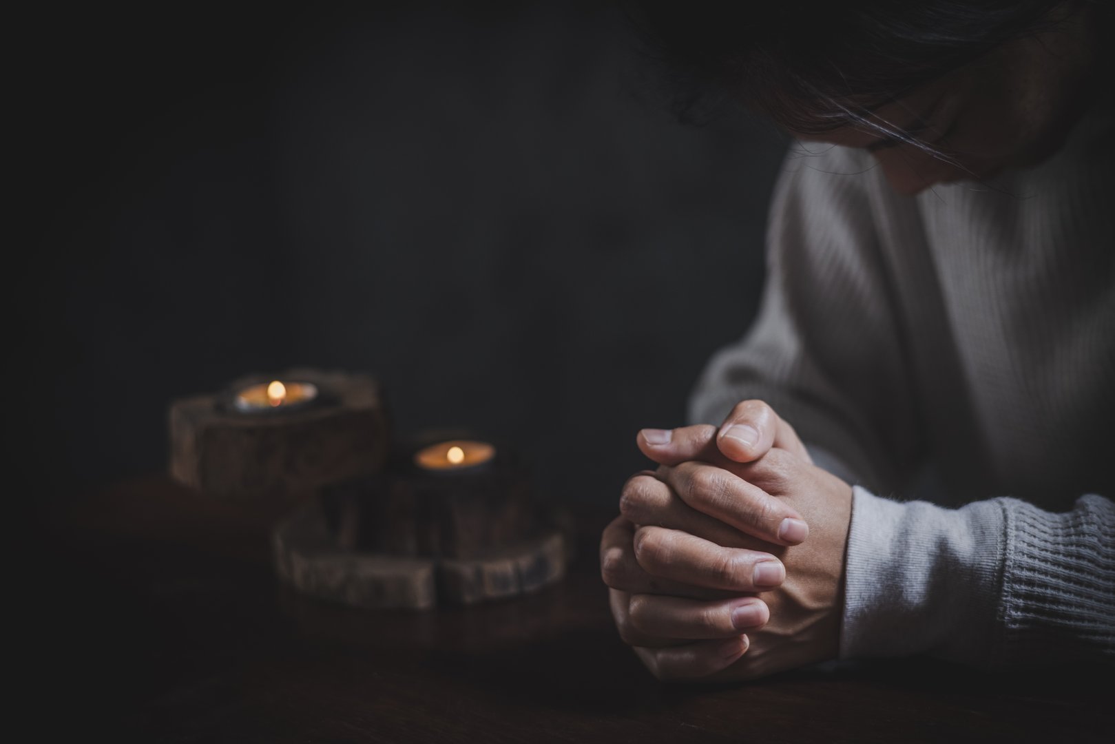 woman's hands clasped together in a moment of prayer or deep contemplation showcasing inner thoughts.