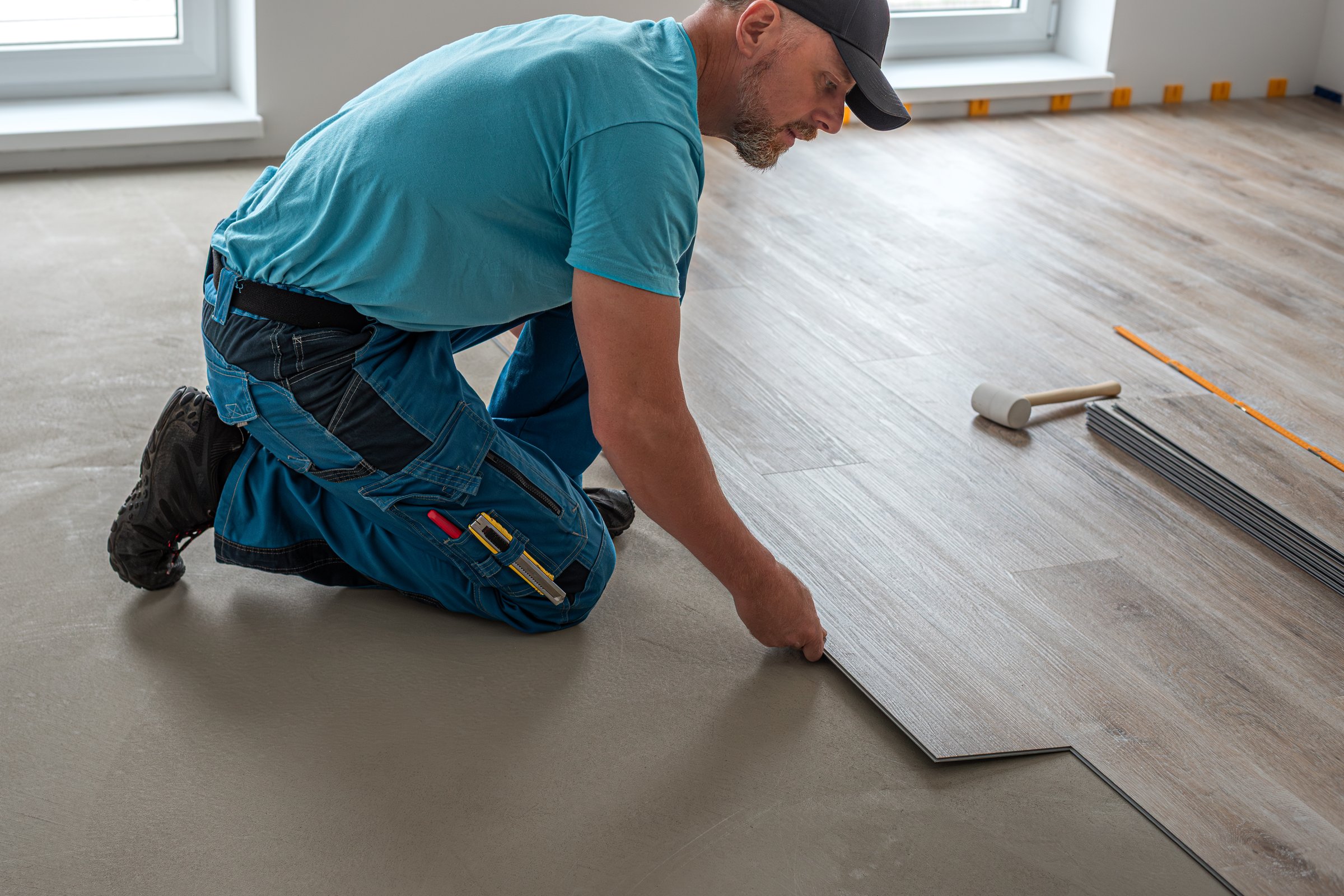 Professional flooring worker installing vinyl plank