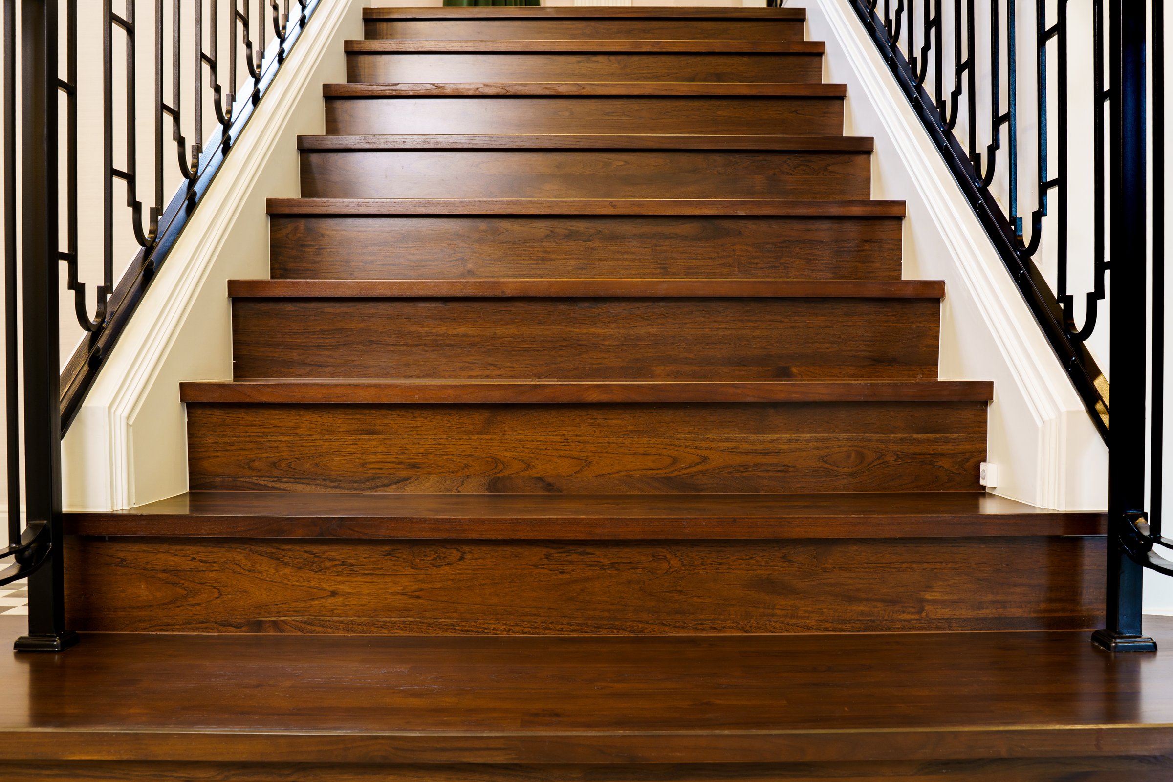 A dark teak wooden staircase showcasing the rich texture and natural details of the wood, highlighting craftsmanship and elegance in interior design and architectural concepts.
