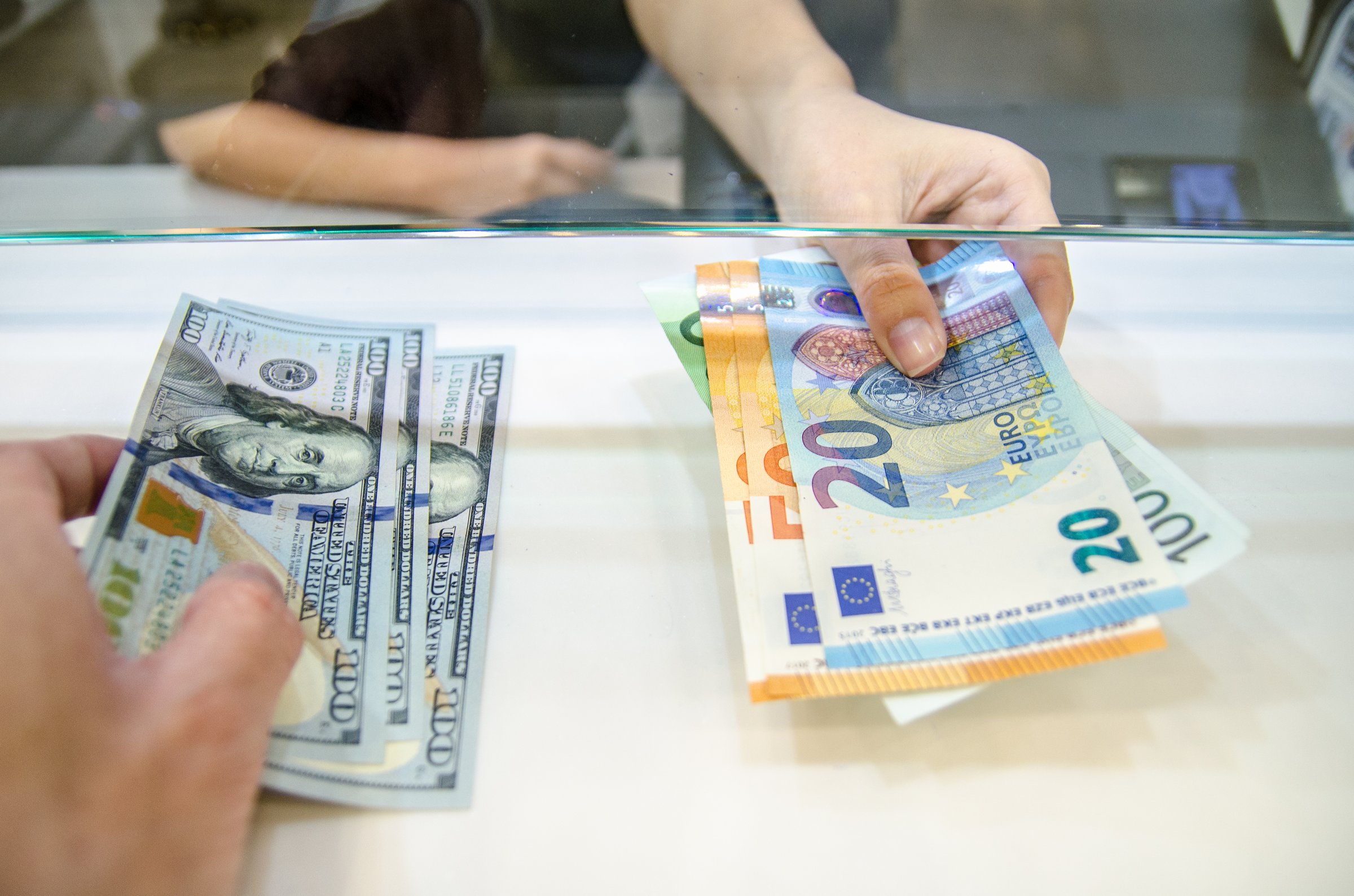 Exchange money, Exchange US dollar or American dollars (USD) for EUR money, A man and women are exchanging dollars for euros