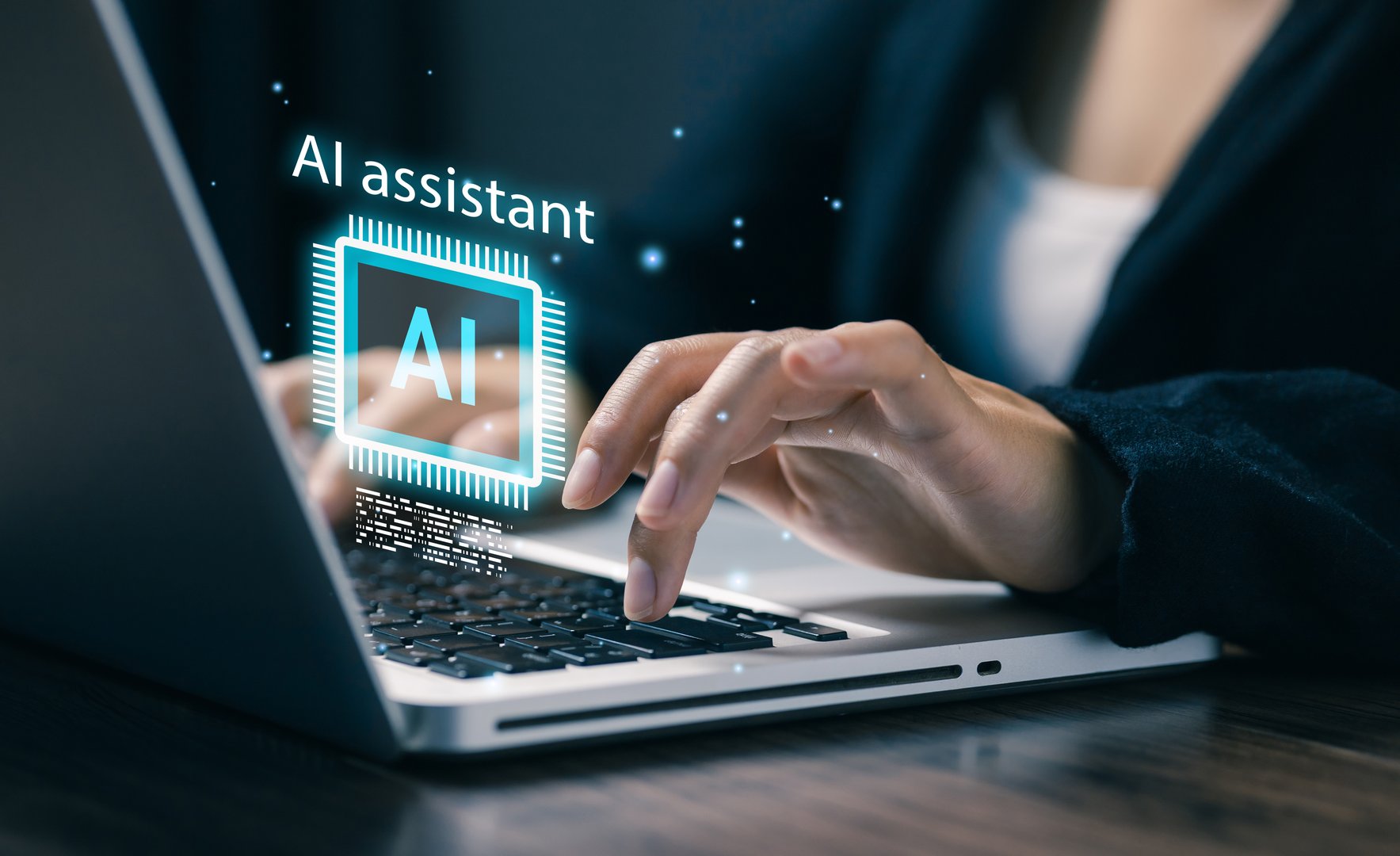 Person using laptop with holographic AI assistant icon. Concept of artificial intelligence, productivity tools, digital innovation, and smart technology in modern business.