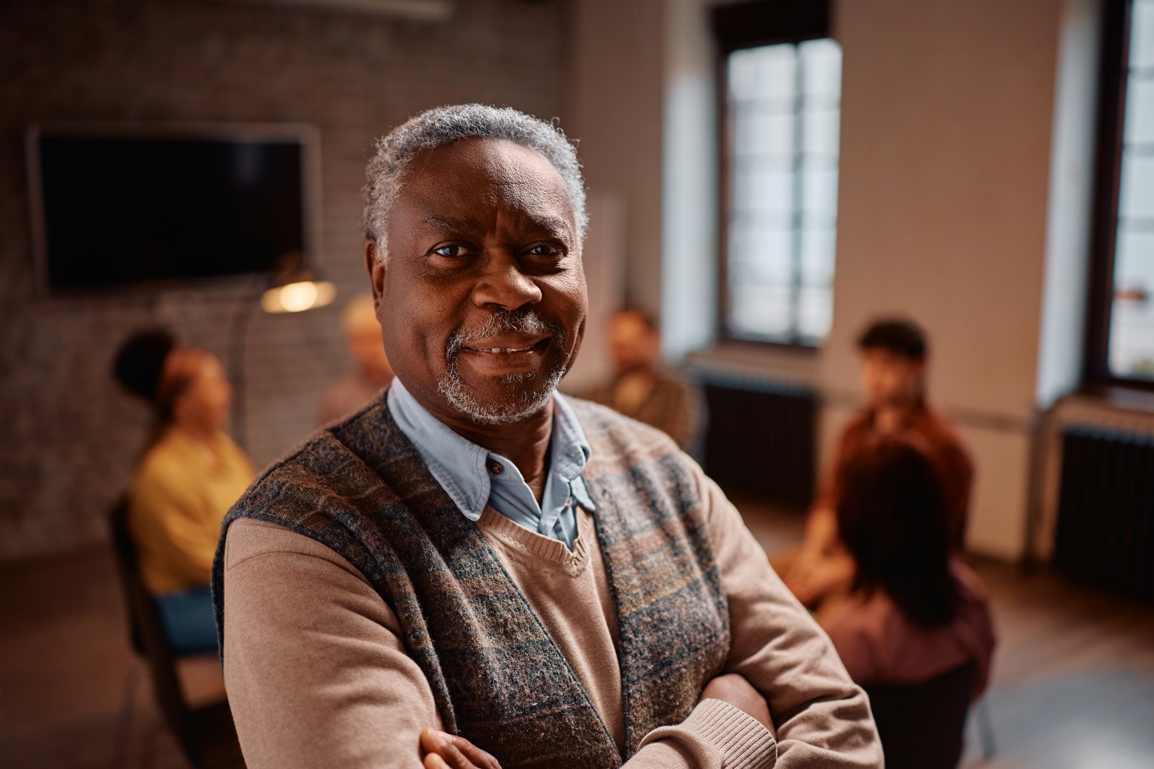 African American senior participating in mental health counseling at community center looking at camera.