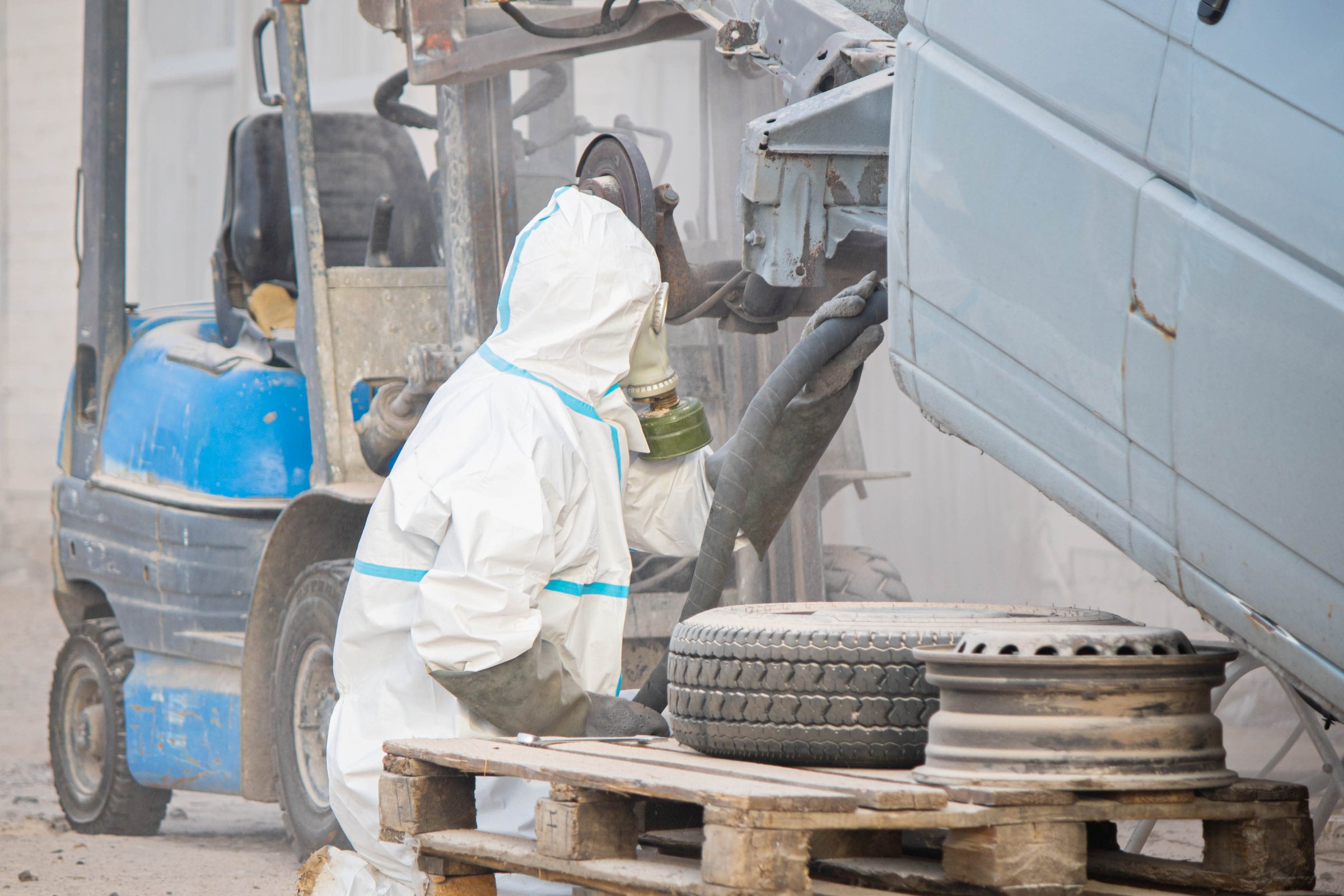 industrial processing of rusty metal of a car body with a sandblasting machine