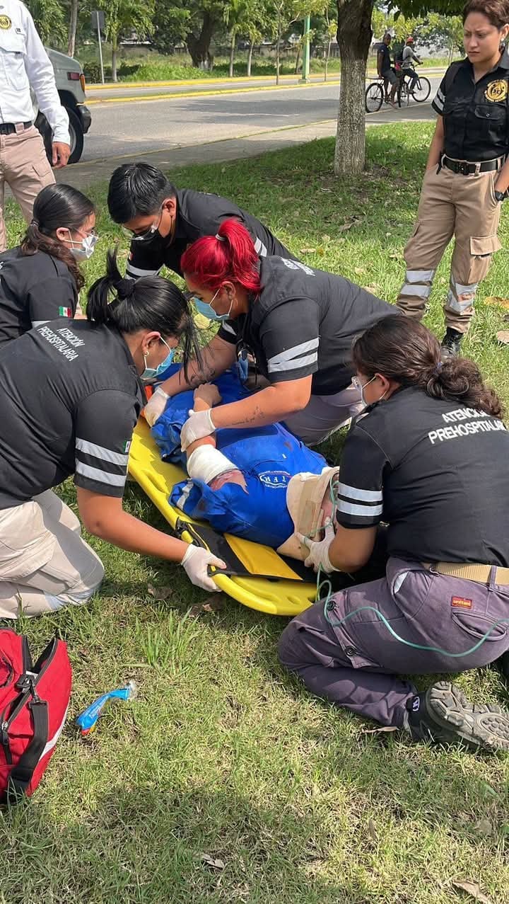 Emergency responders practice CPR on a mannequin outdoors, demonstrating first aid skills in a training exercise.