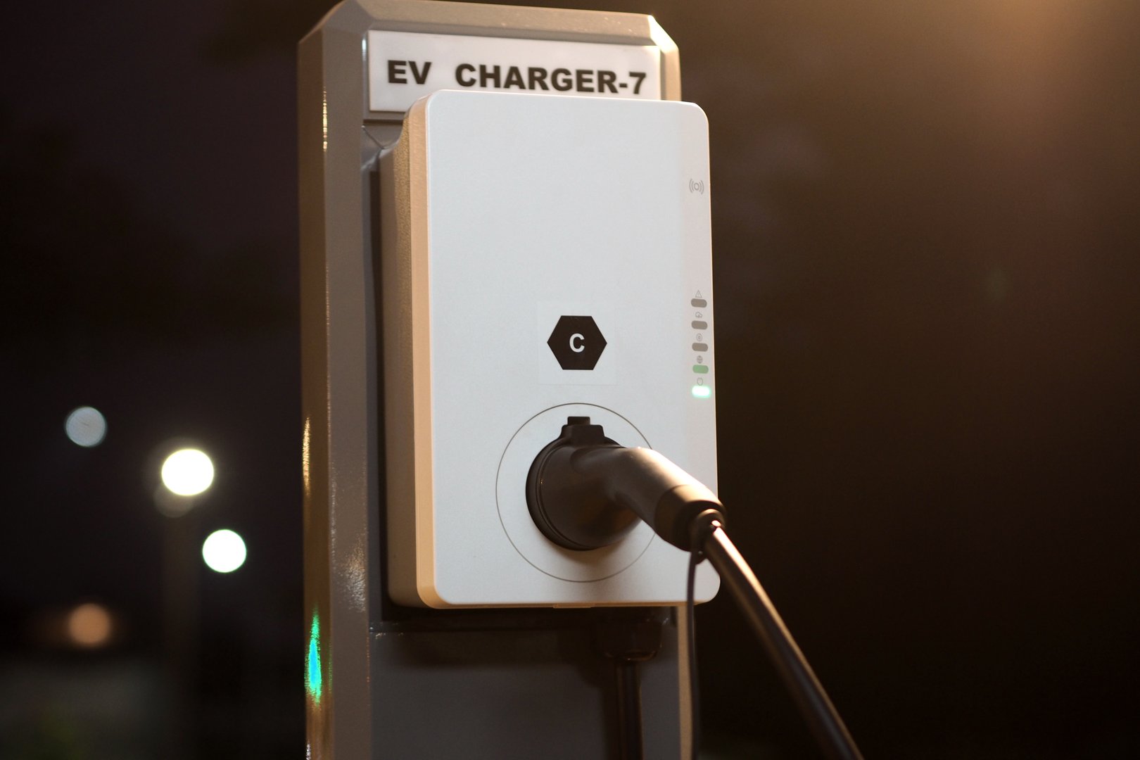 EV charging and electric car, Electric car charging station for charge EV battery, Plug for vehicle with electric engine, EV charger clean energy, Charging point at car parking lot.