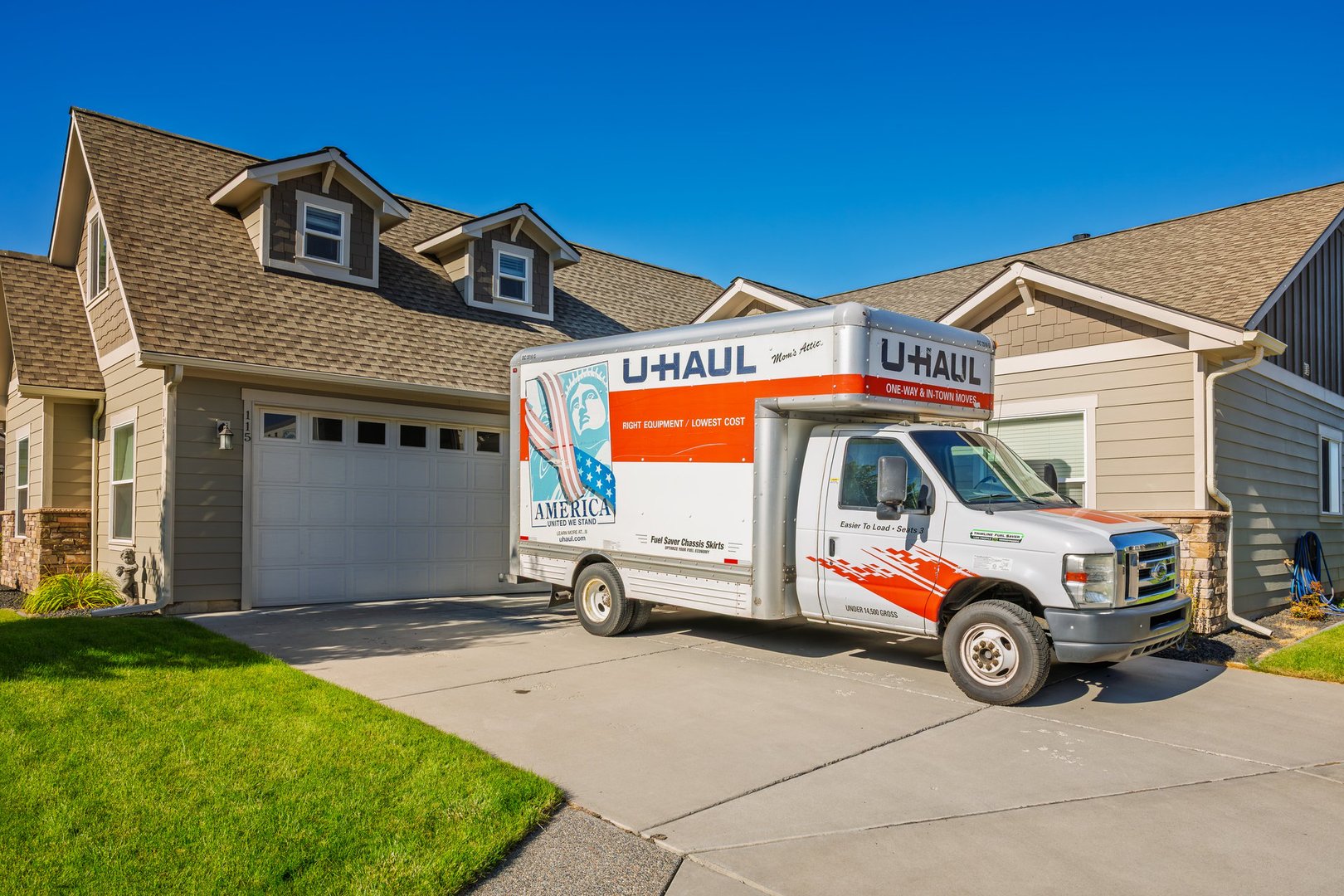 U-Haul rental moving truck parked in the driveway of a suburban home