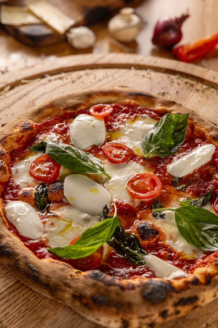 Artisan wood fired margherita pizza on rustic table