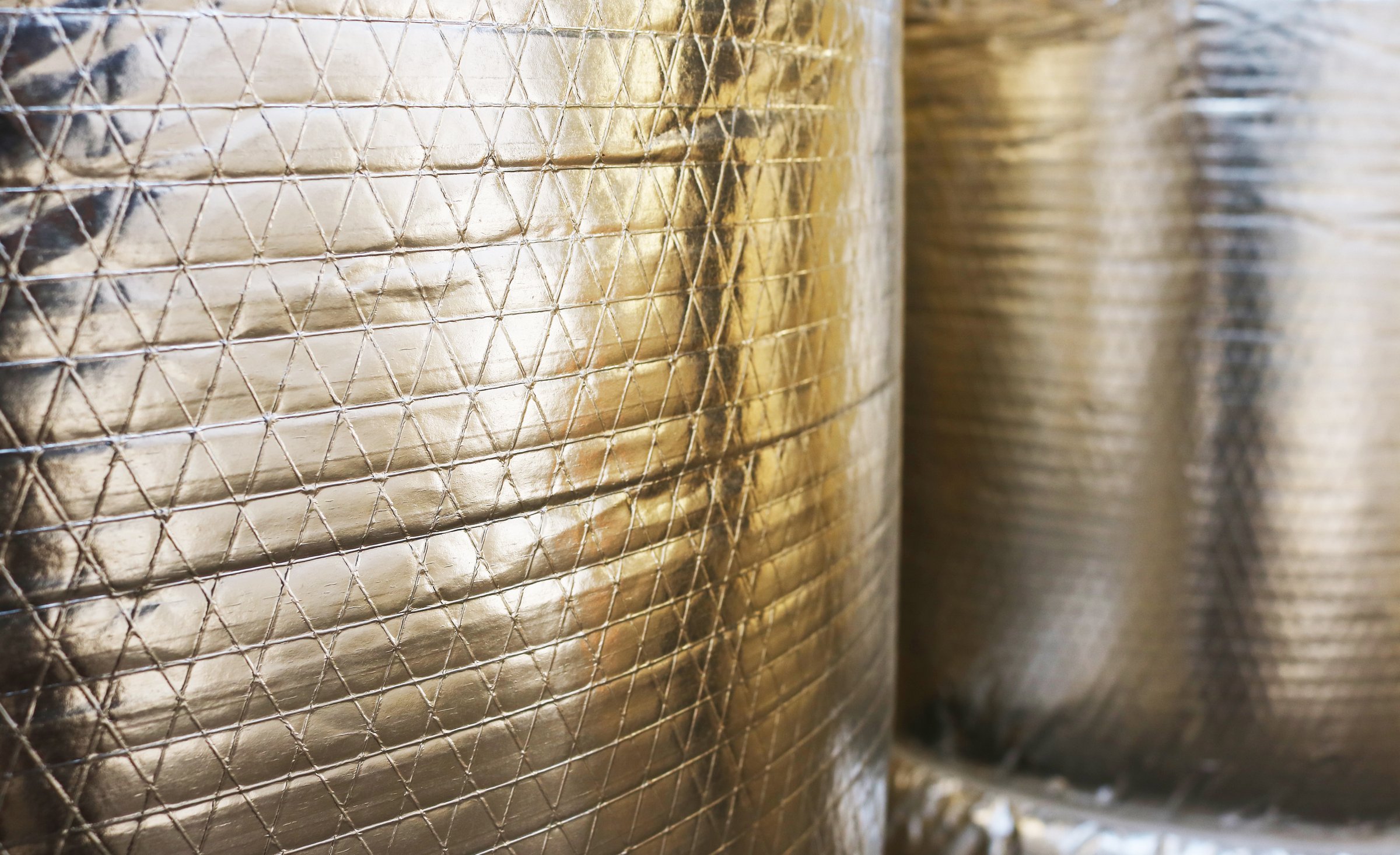 Close-up aluminium foil insulation roll pattern background.