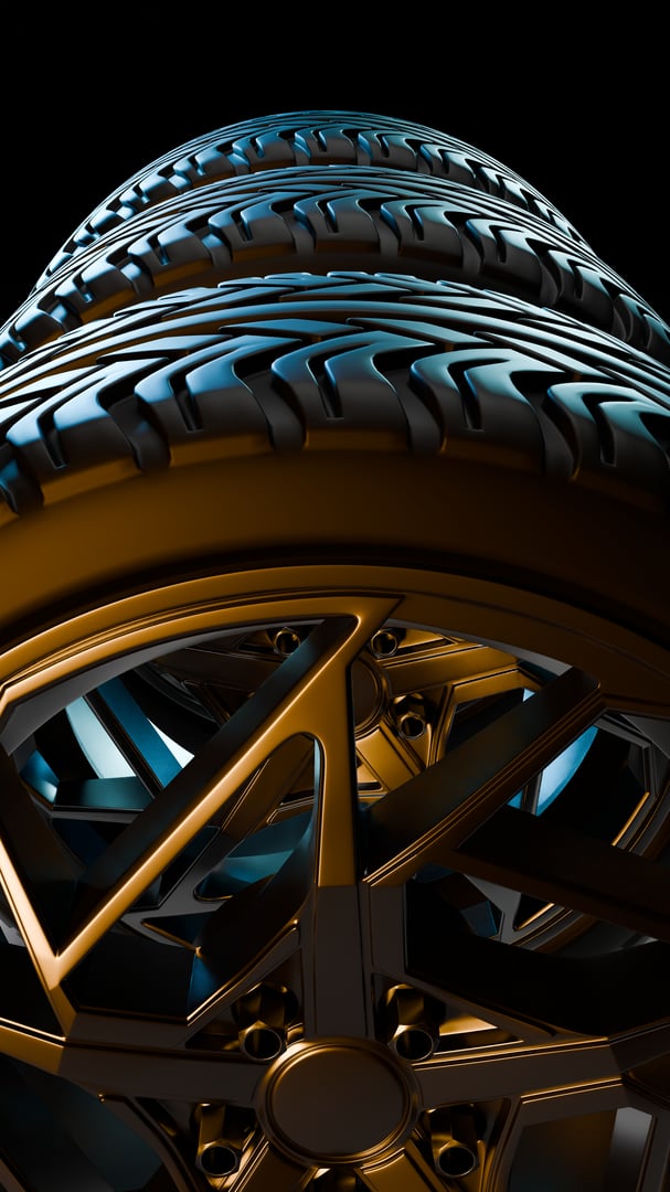 A closeup macro shot of a golden alloy rim and attached black tire with visible tread patterns captured with dramatic lighting for automotive design concepts.