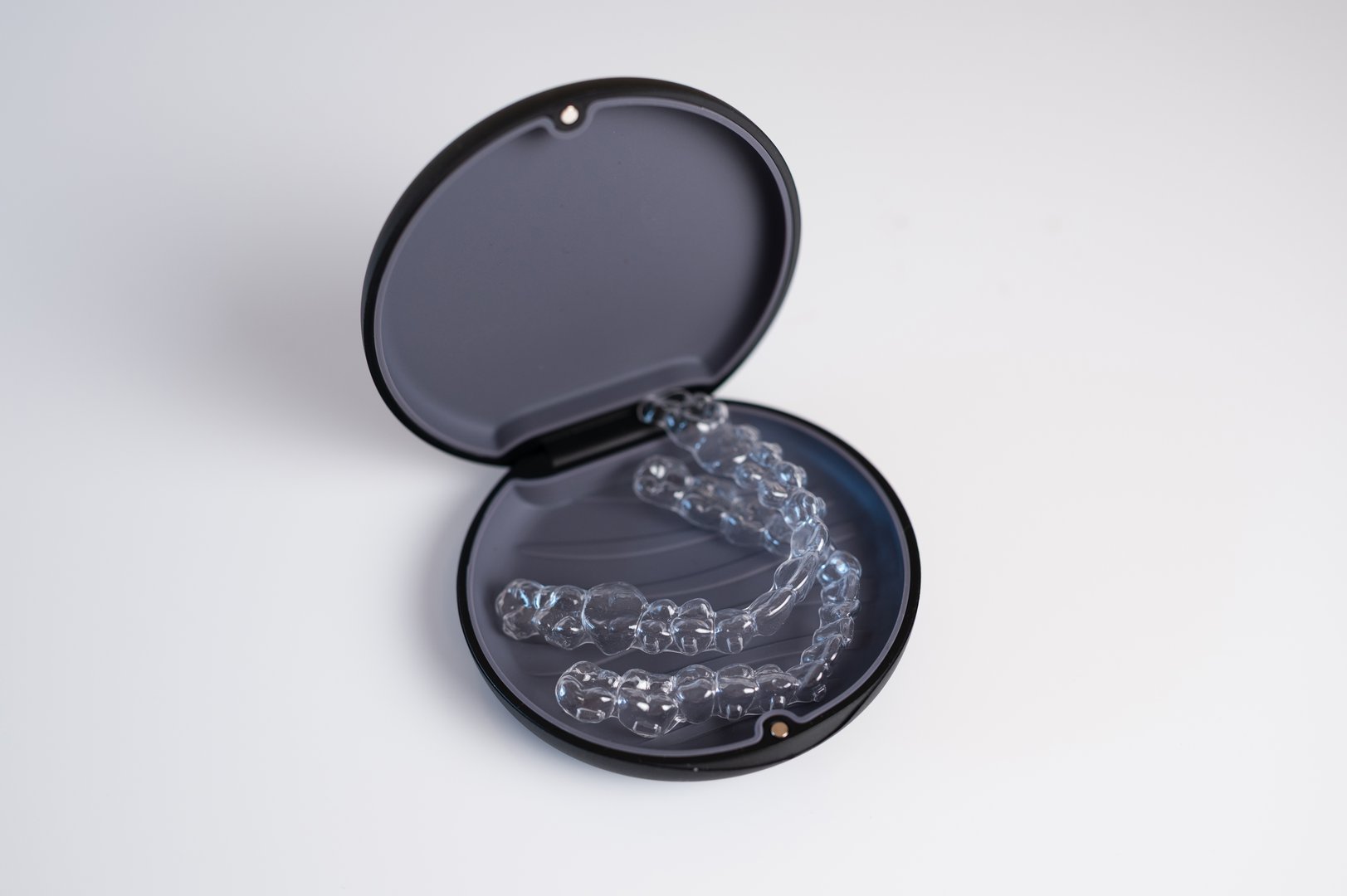 Invisible braces lying in a black opened box on a white background, dental healthcare concept