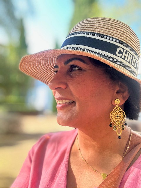 Sonal in profile wearing a stylish hat, embodying confidence and professional elegance