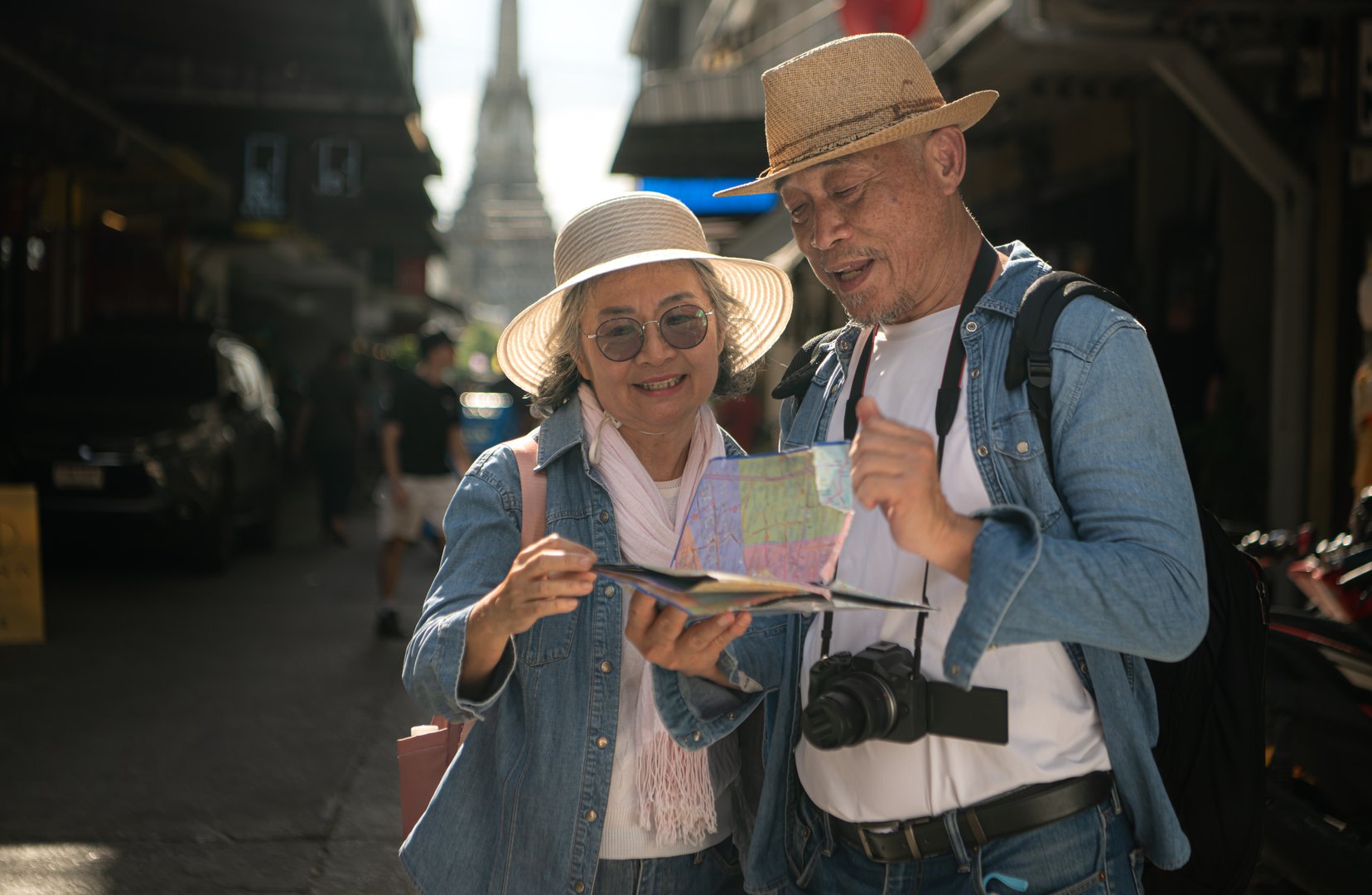 Elderly couples and their activities on the road at the end of the alley where there is a pagoda of Wat Arun, Thailand