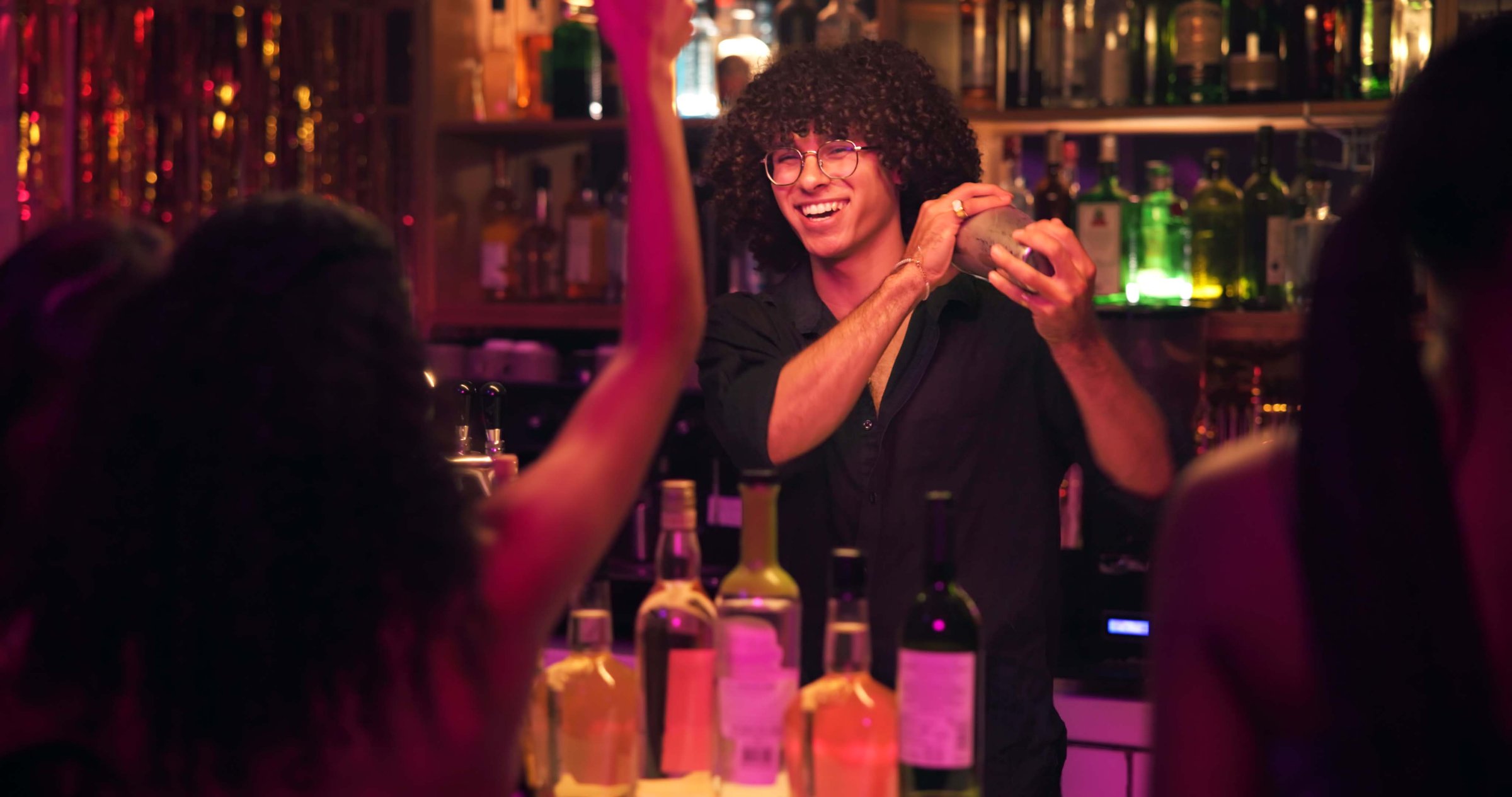 Barman, shaker and people for cocktail at nightclub with bottle service, skills and liquor for event. Person, bartender and patron with mixing, alcohol and spirits for drinks, catering or job at pub