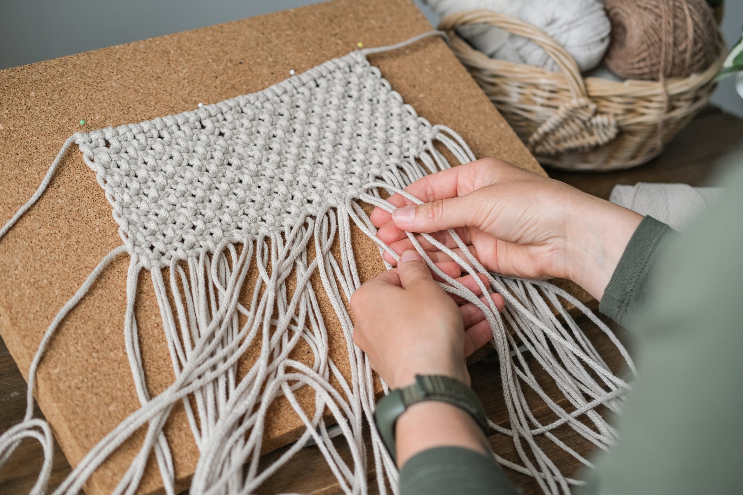 Close up of female hands weaving macrame