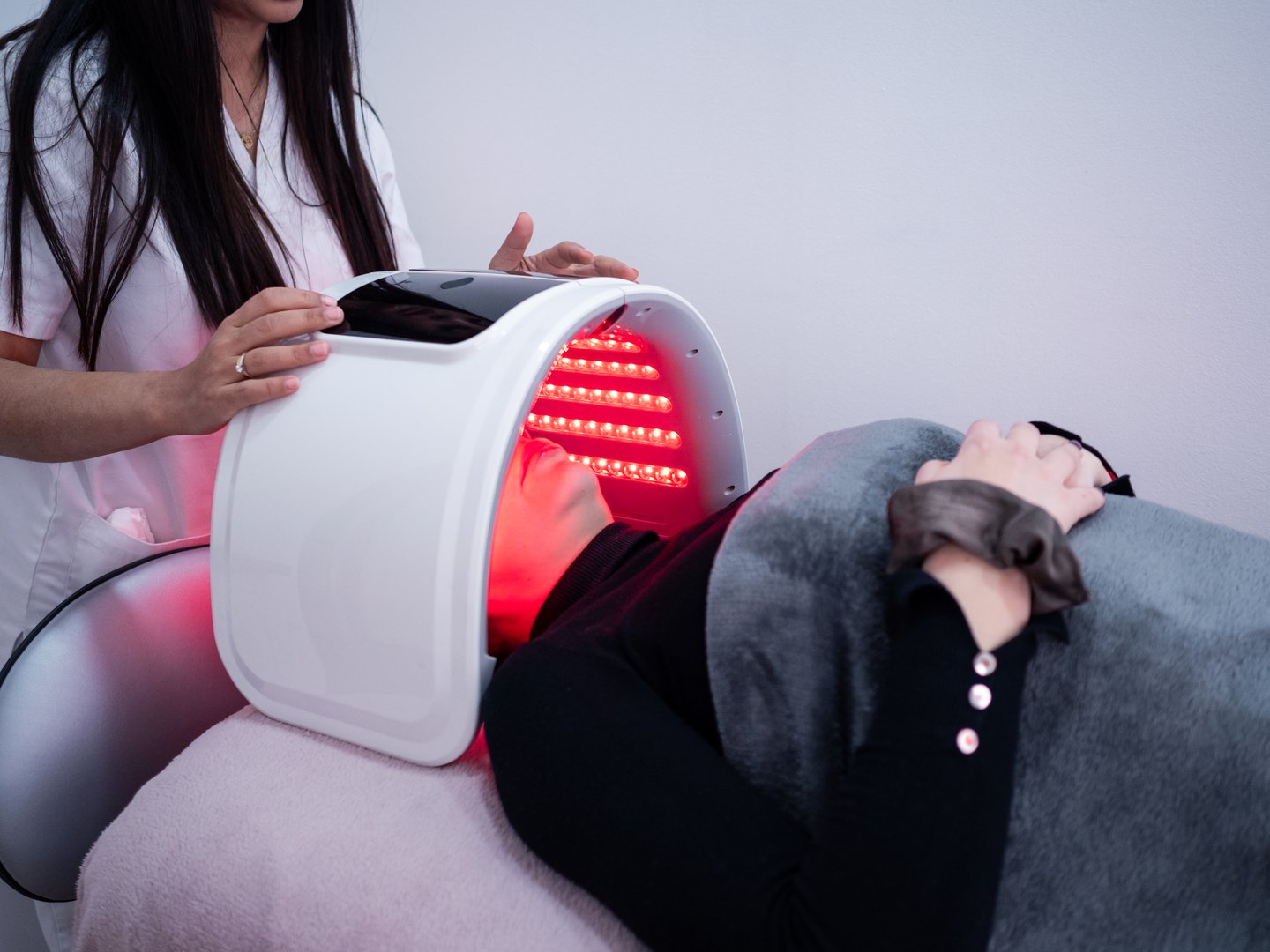 Woman enjoys LED light mask therapy session