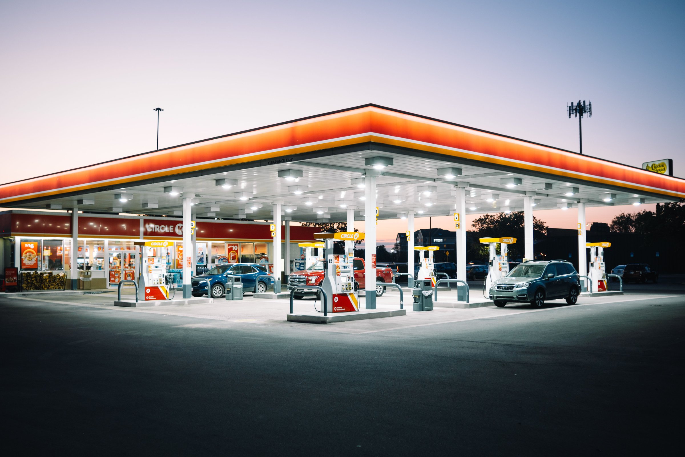 Toledo Ohio, United States – September 19, 2024: A brightly lit gas station at dusk with cars refueling and a convenience store in the background.